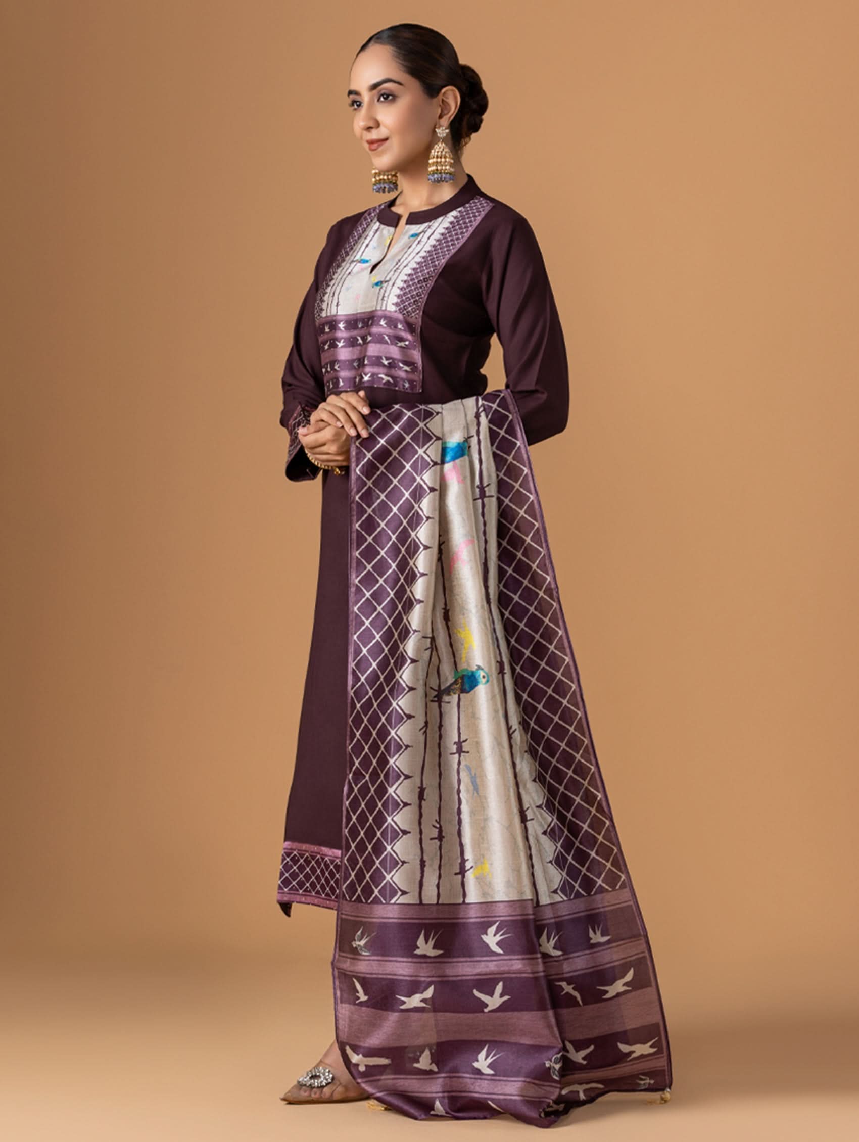 Woman wearing a traditional outfit with a patterned skirt on a beige background
