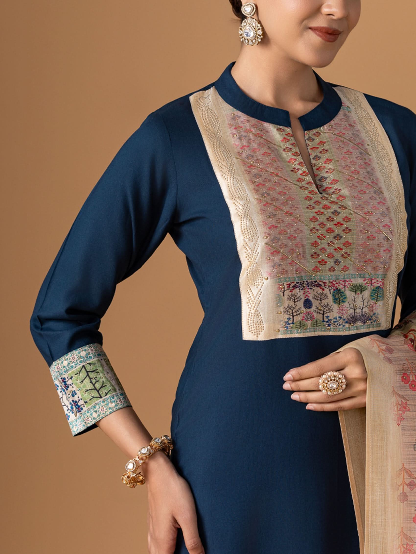 Navy blue traditional outfit with floral patterns on a beige background