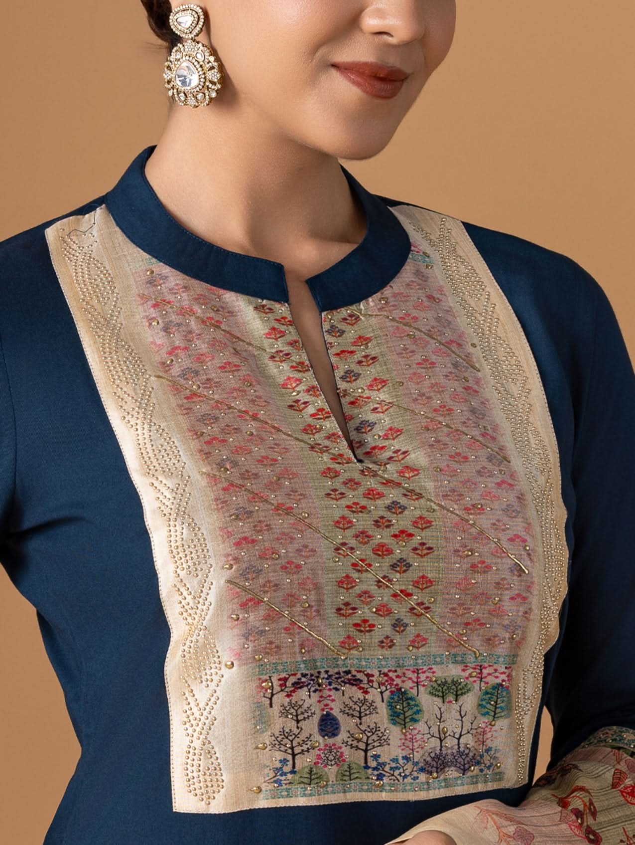 Close-up of a traditional outfit with floral embroidery on a beige background
