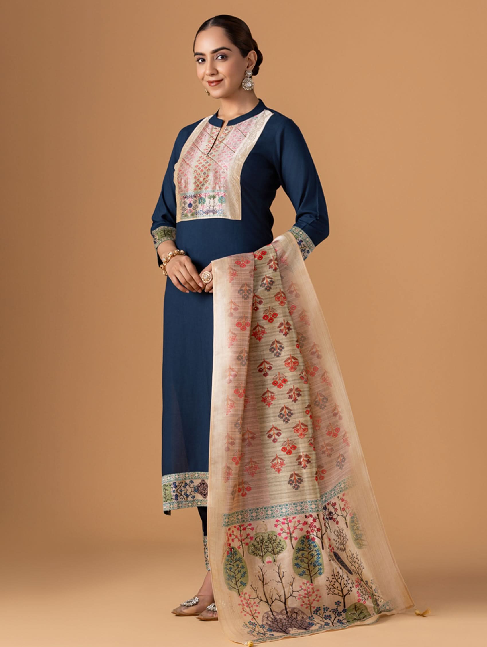 Woman wearing a navy blue top and floral skirt on a beige background