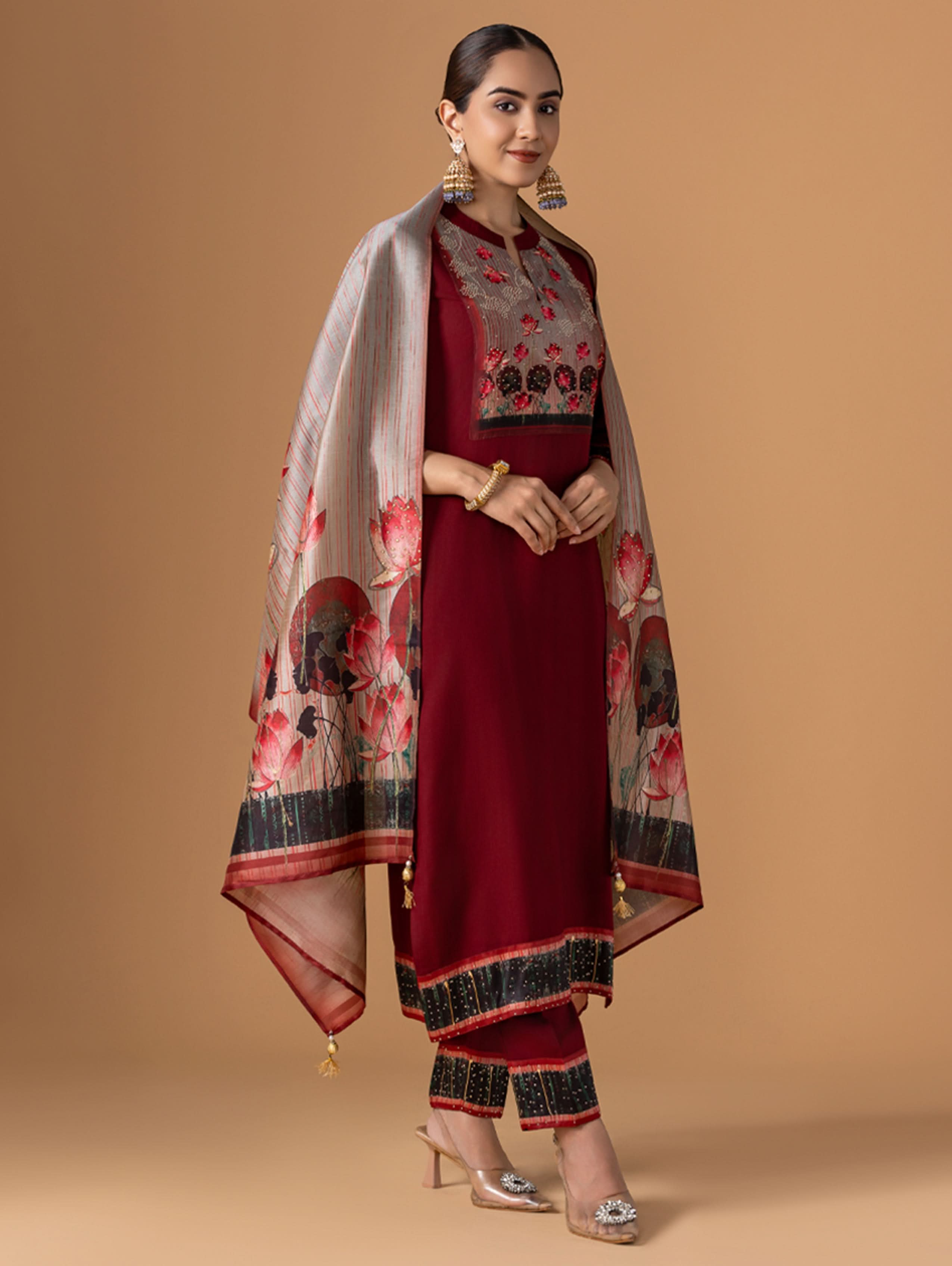 Woman wearing a red traditional outfit with floral patterns on a beige background