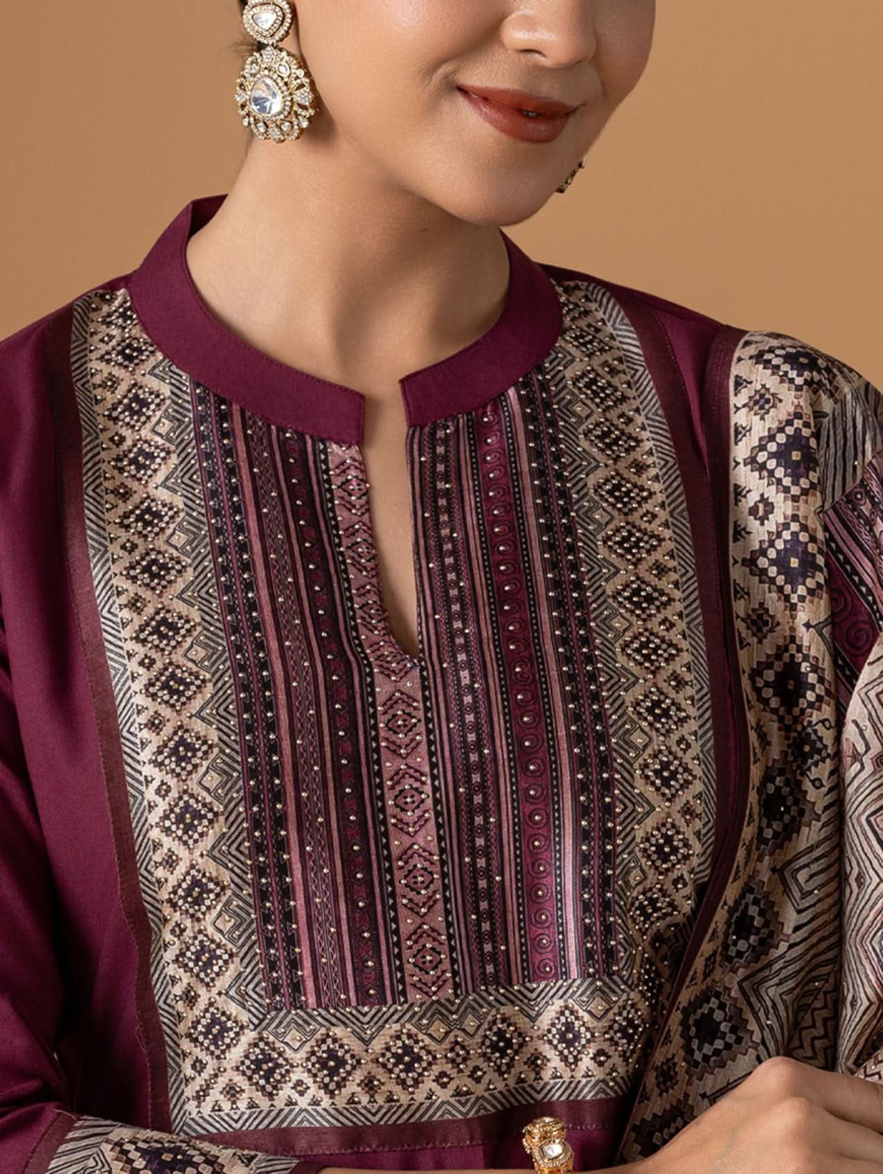 Close-up of a person wearing a patterned shirt with a beige background