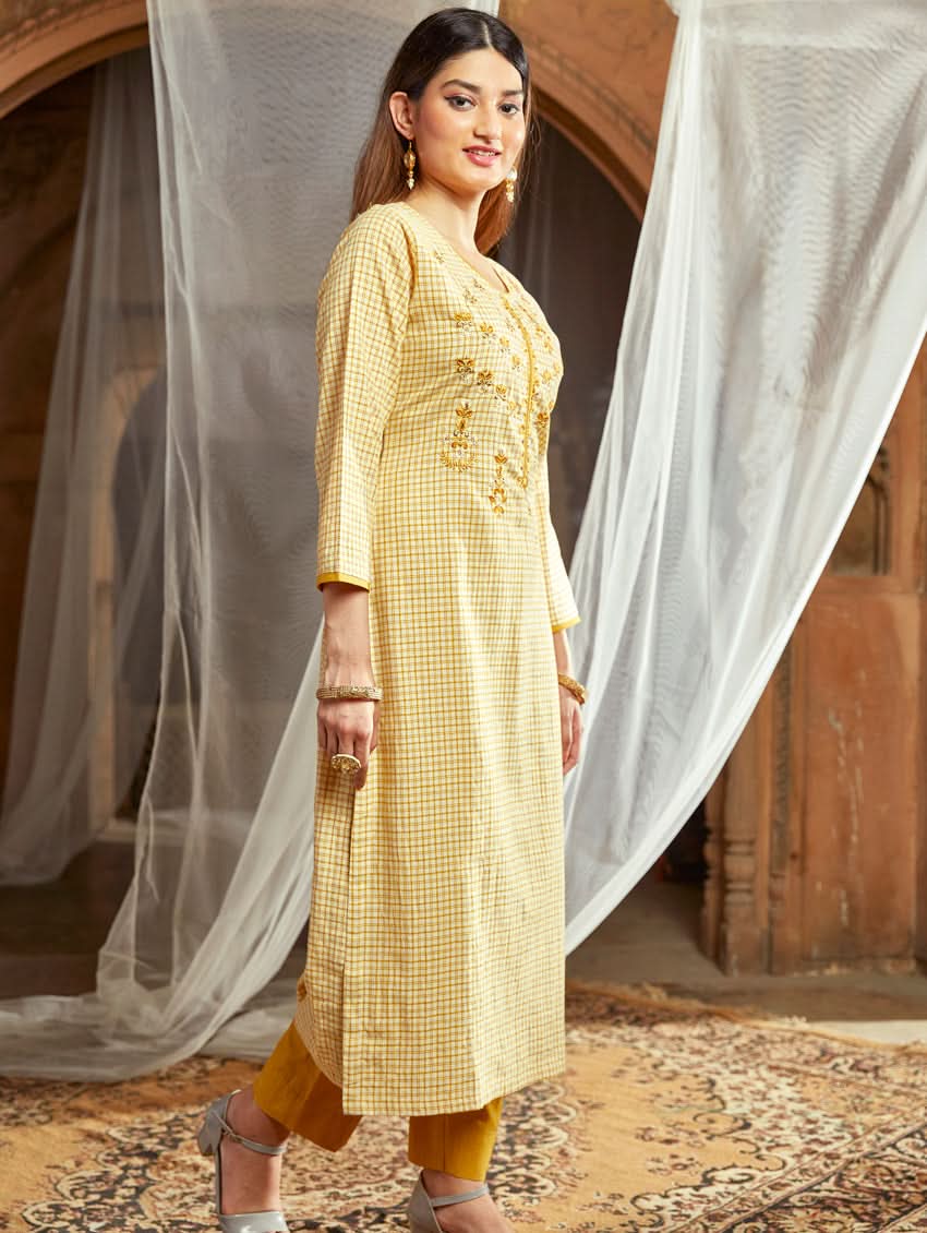 Women wearing a Yellow checkered Kurta with round neckline and computer embroidered with three fourth sleeves