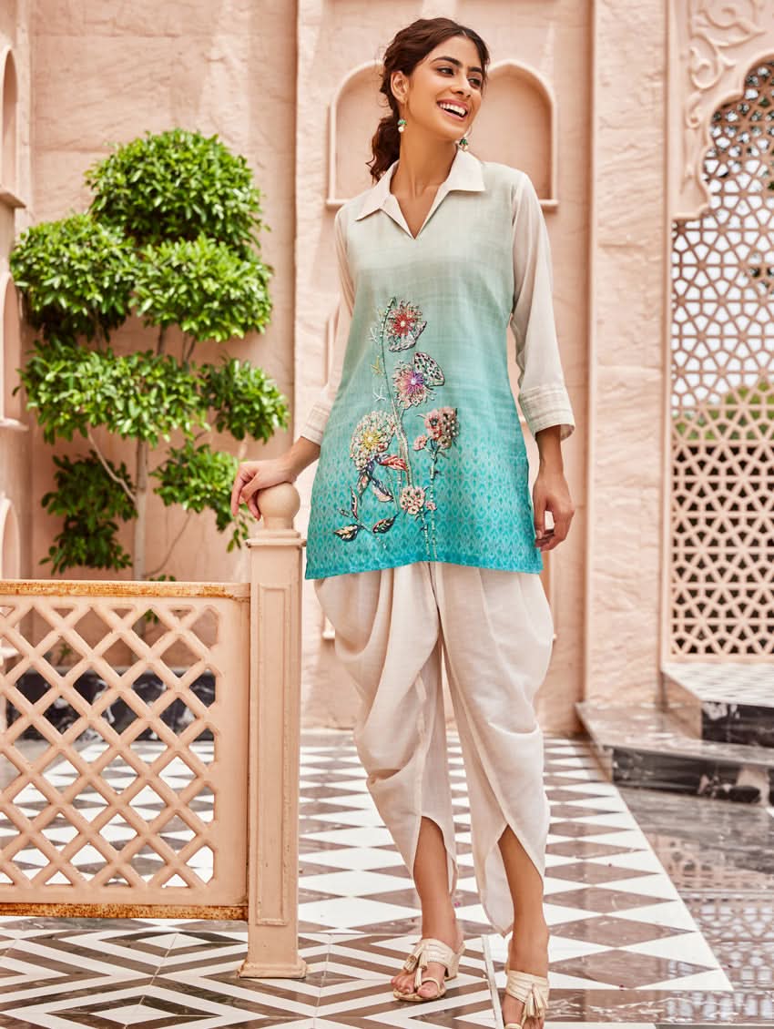 A woman standing outdoors wearing an printed cotton co-ord set with a rever neckline, three-quarter sleeves, and pockets on either side.