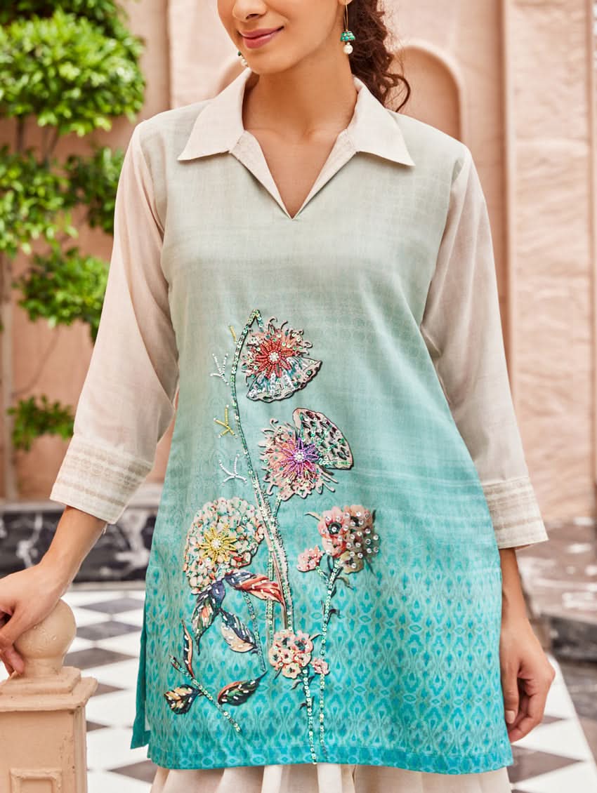 A woman standing outdoors wearing an printed cotton co-ord set with a rever neckline, three-quarter sleeves, and pockets on either side.