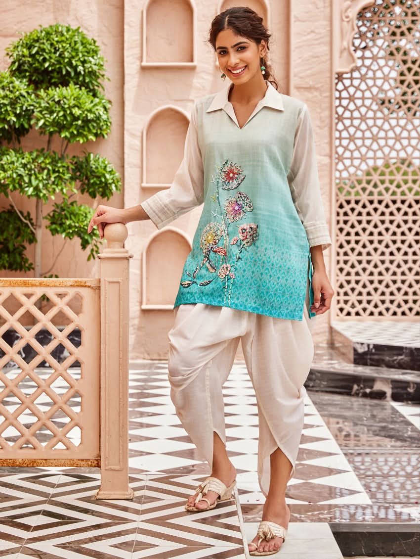 A woman standing outdoors wearing an printed cotton co-ord set with a rever neckline, three-quarter sleeves, and pockets on either side.