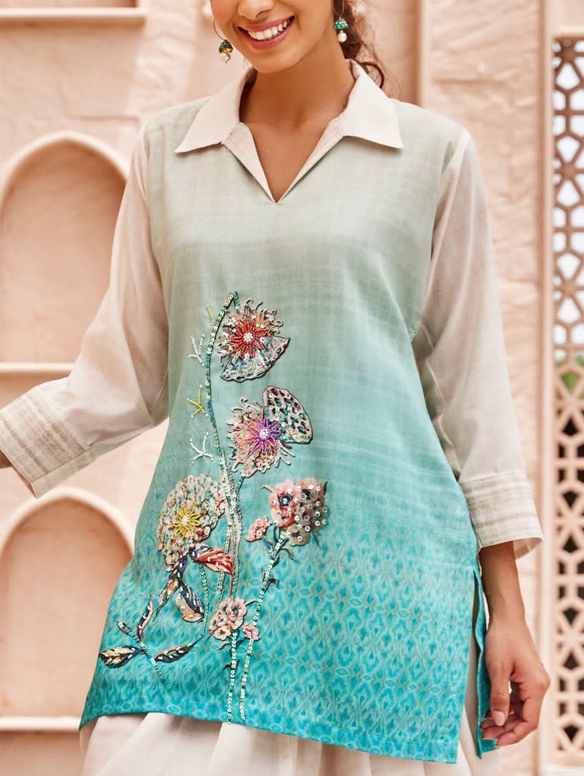 A woman standing outdoors wearing an printed cotton co-ord set with a rever neckline, three-quarter sleeves, and pockets on either side.
