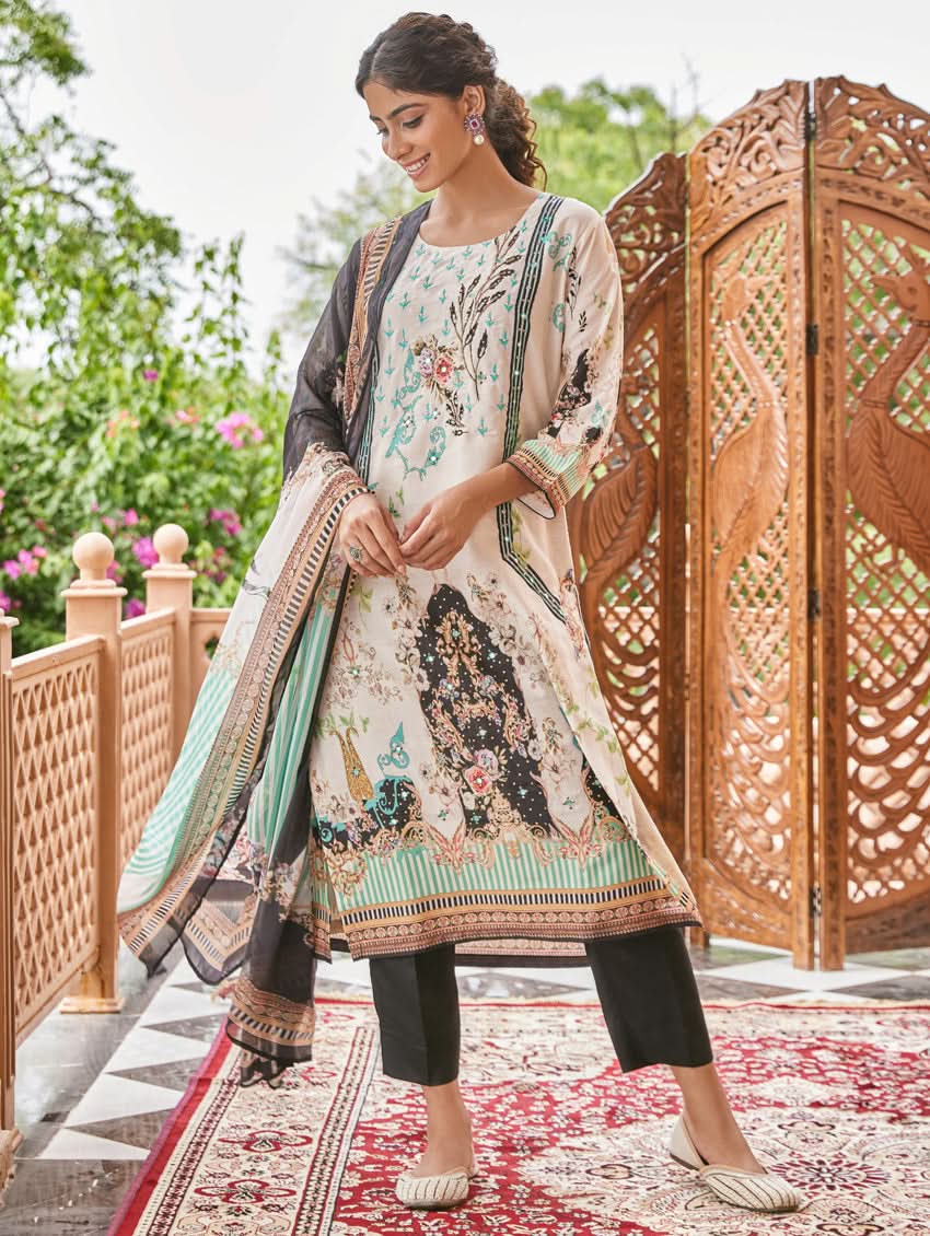 A woman wearing a traditional digital printed silk suit set with a dupatta, featuring a round neckline, three-fourth sleeves, and side slits. The set has a vibrant floral design.