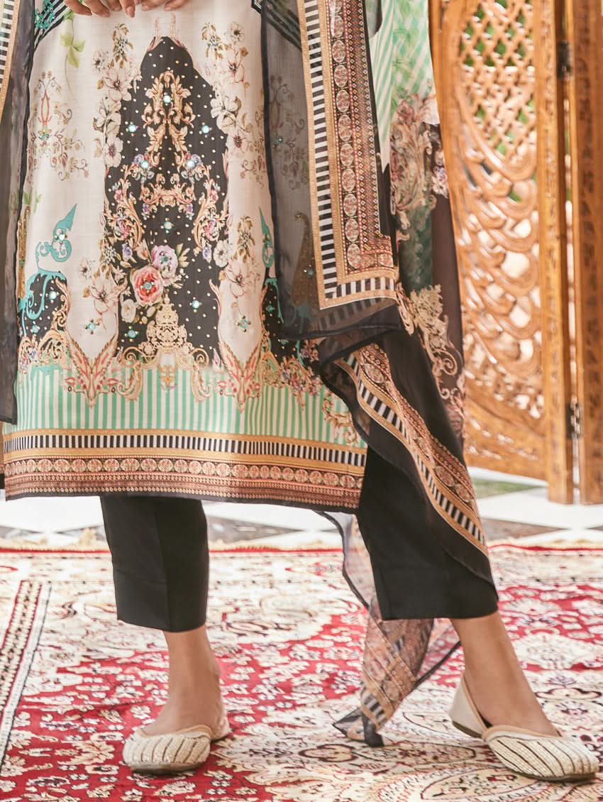 A woman wearing a traditional digital printed silk suit set with a dupatta, featuring a round neckline, three-fourth sleeves, and side slits. The set has a vibrant floral design.