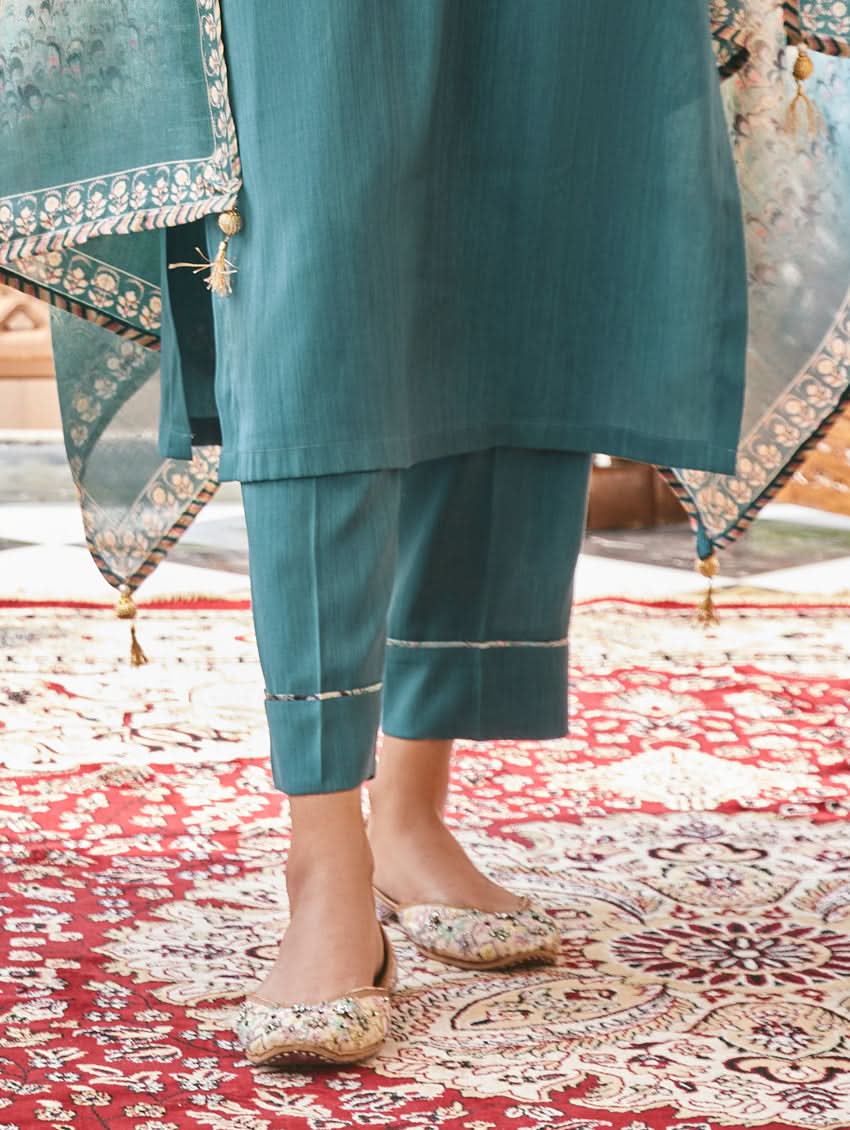 Teal silk pants with straight hem and subtle embroidered trim; paired with kurta