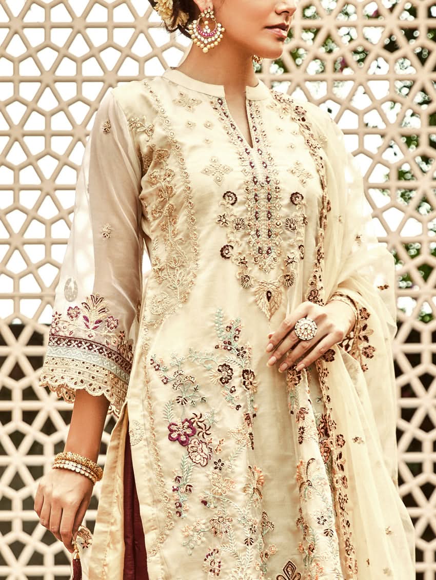 Cream embroidered tunic with button placket and ornate floral accents, sheer sleeve cuffs