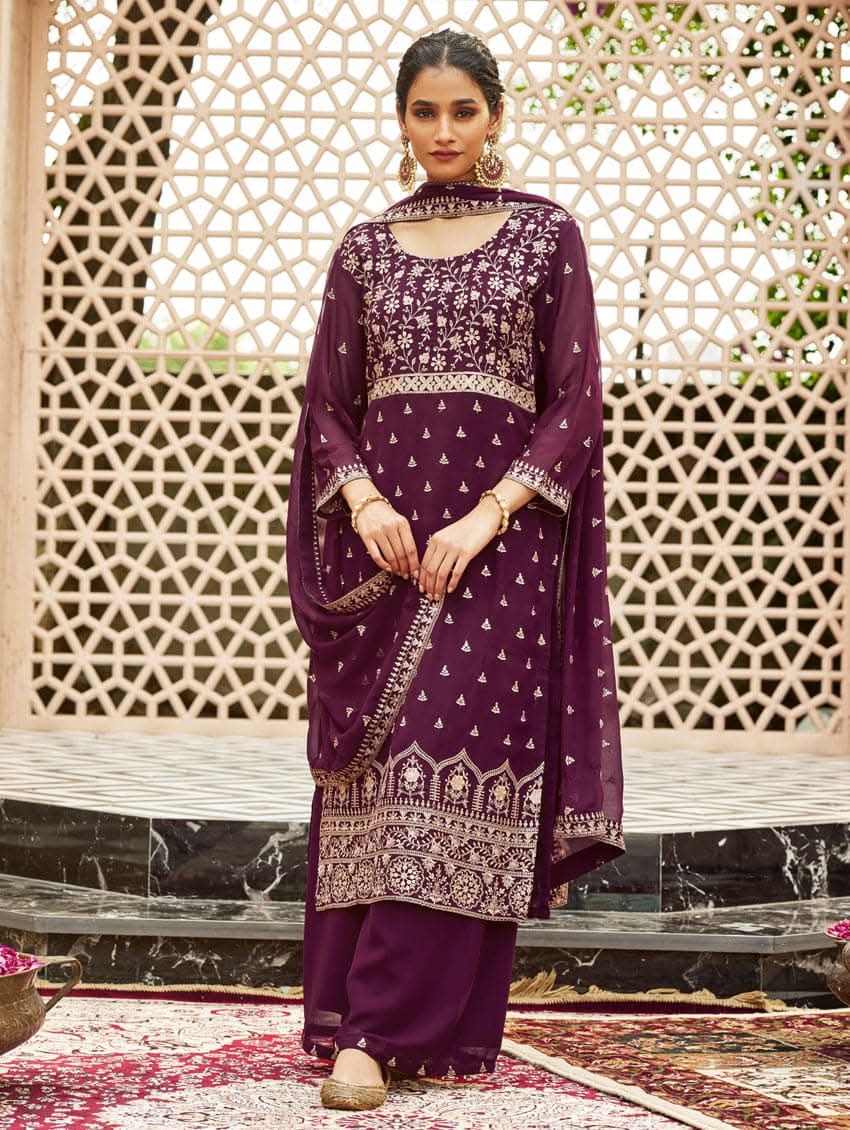 A woman wearing a traditional purple kurta set with embroidered details and a dupatta with a georget design, with dupatta
