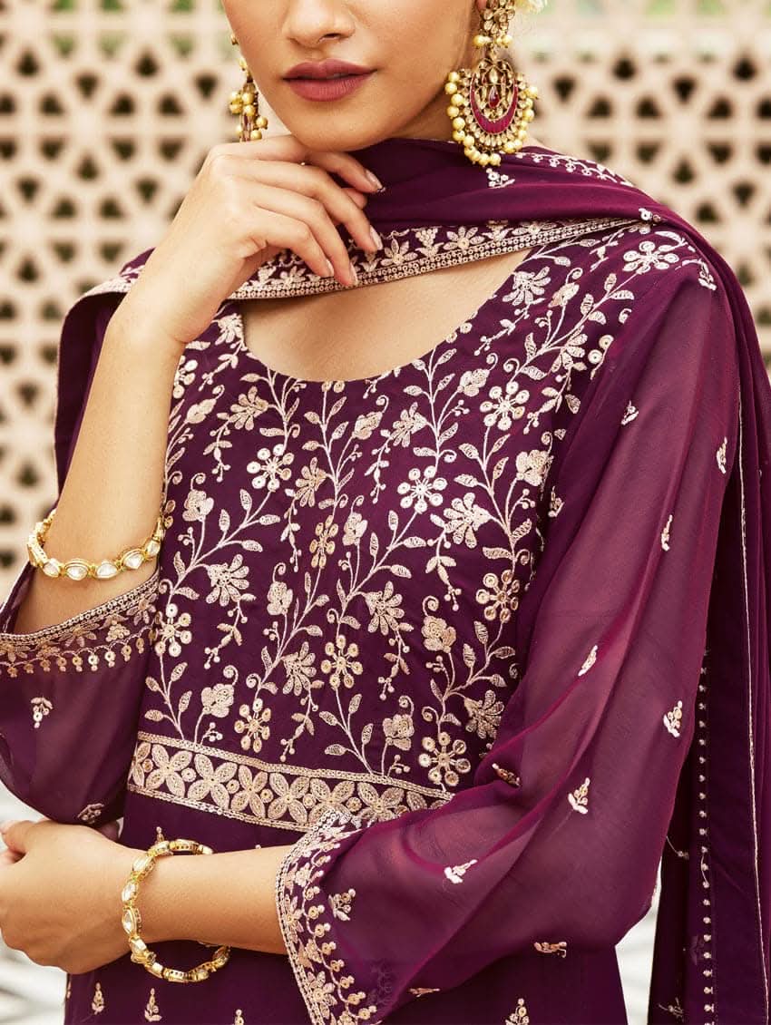A woman wearing a traditional purple kurta set with embroidered details and a dupatta with a georget design, with dupatta