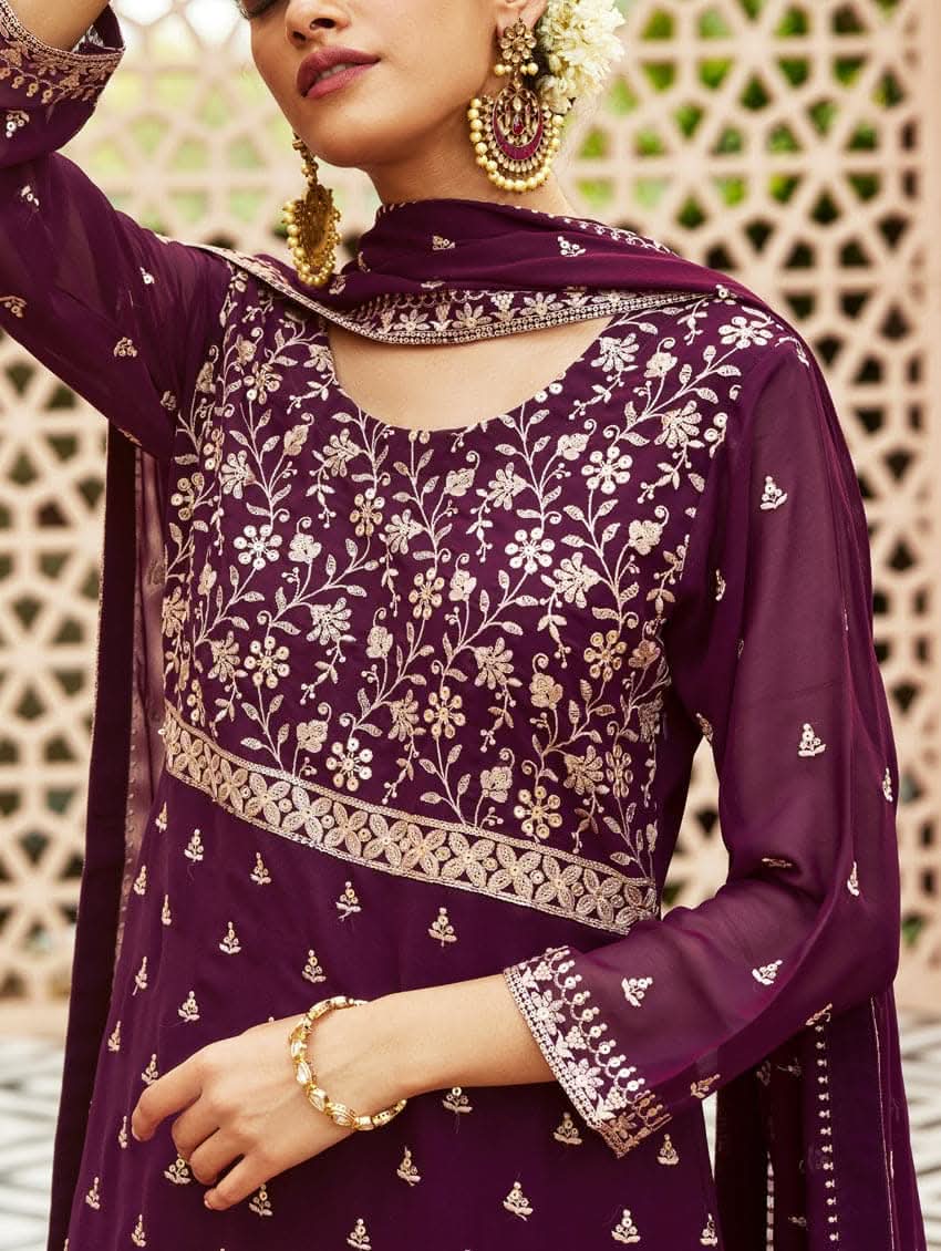 A woman wearing a traditional purple kurta set with embroidered details and a dupatta with a georget design, with dupatta