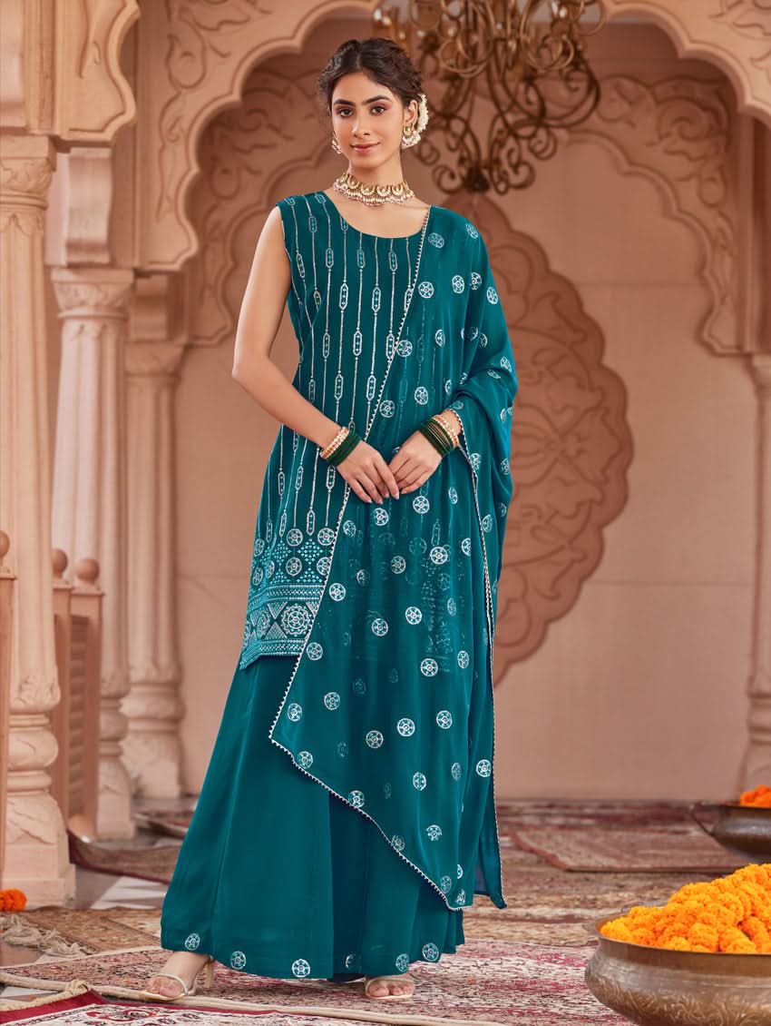 A woman wearing a traditional green Georgette suit set with embroidered sequins, consisting of a kurta with round neckline and sleeveless design, and a sharara with an elasticated waistband. The set is complemented by a dupatta.