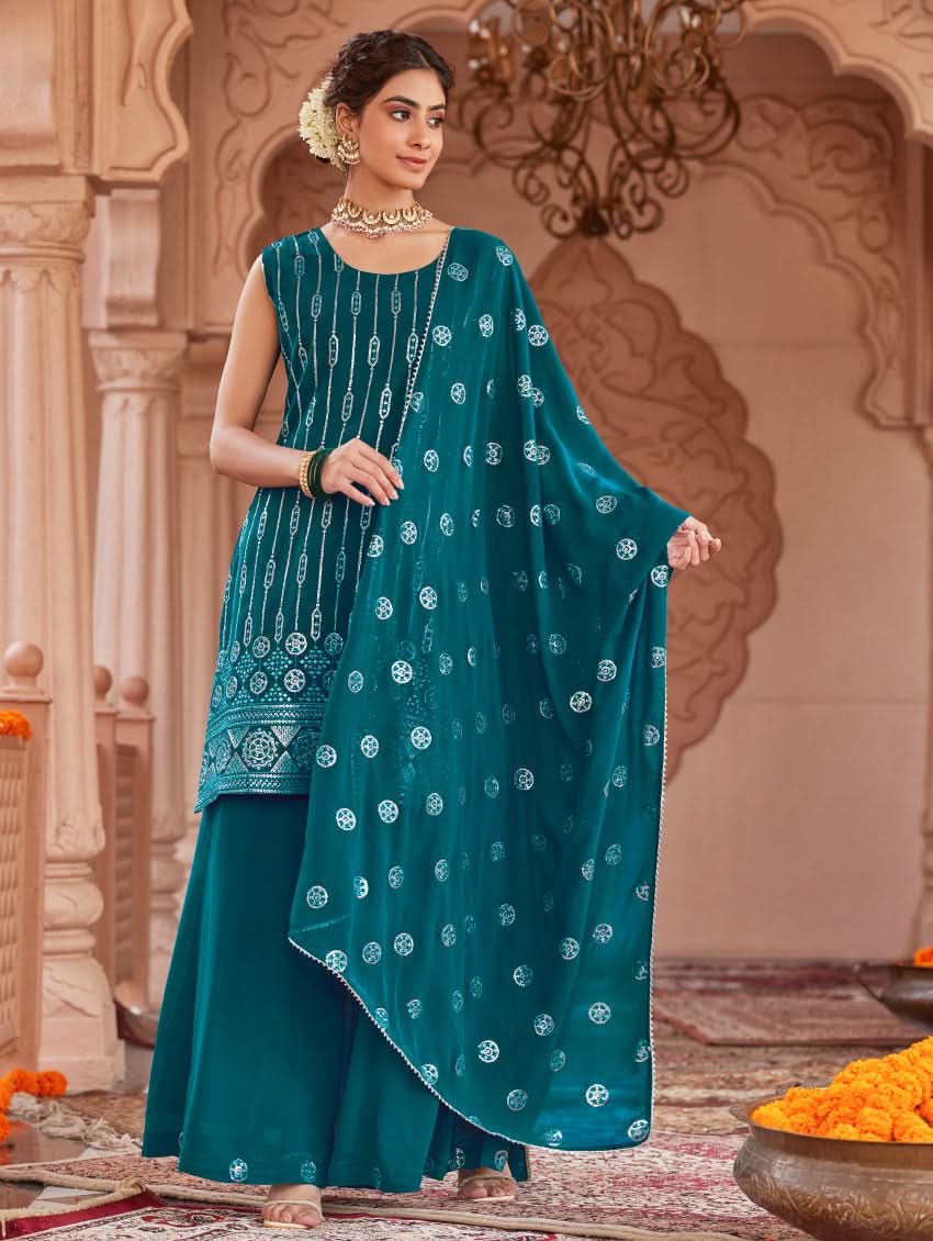 A woman wearing a traditional green Georgette suit set with embroidered sequins, consisting of a kurta with round neckline and sleeveless design, and a sharara with an elasticated waistband. The set is complemented by a dupatta.