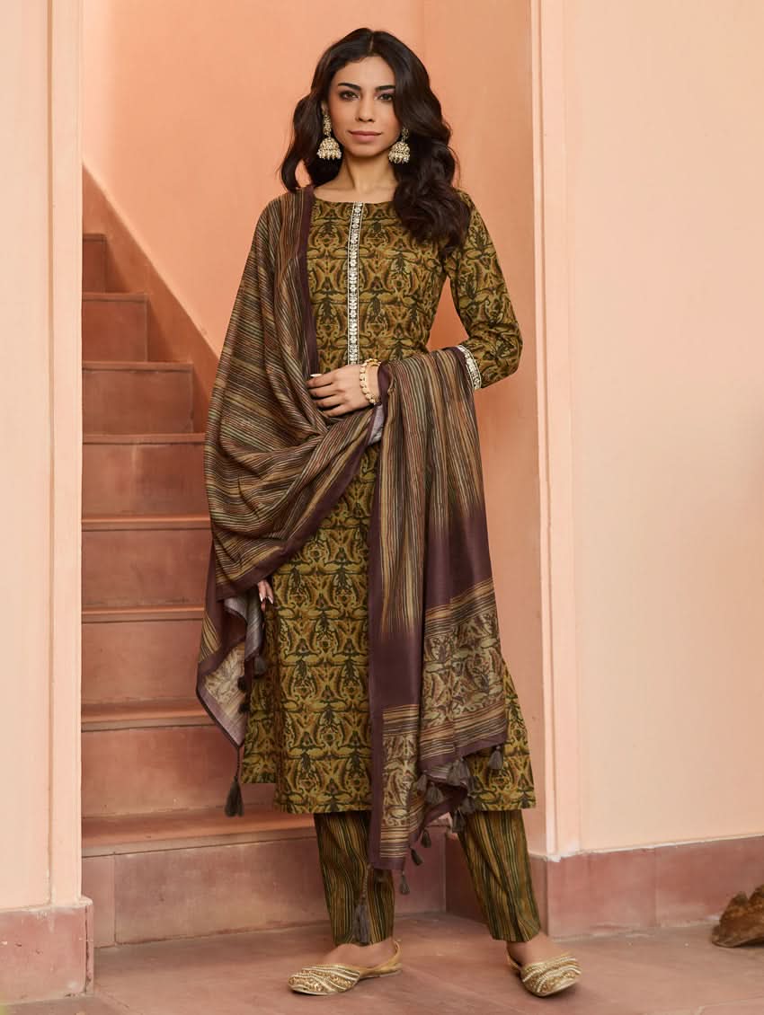 A woman wearing a traditional printed cotton suit set with a dupatta, featuring a boat neckline and embroidery details.
