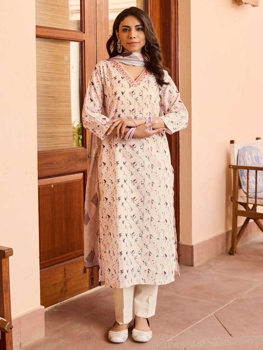 A woman standing outdoors wearing a digitally printed cotton suit set with a kurta, pants, and a dupatta in a floral pattern.