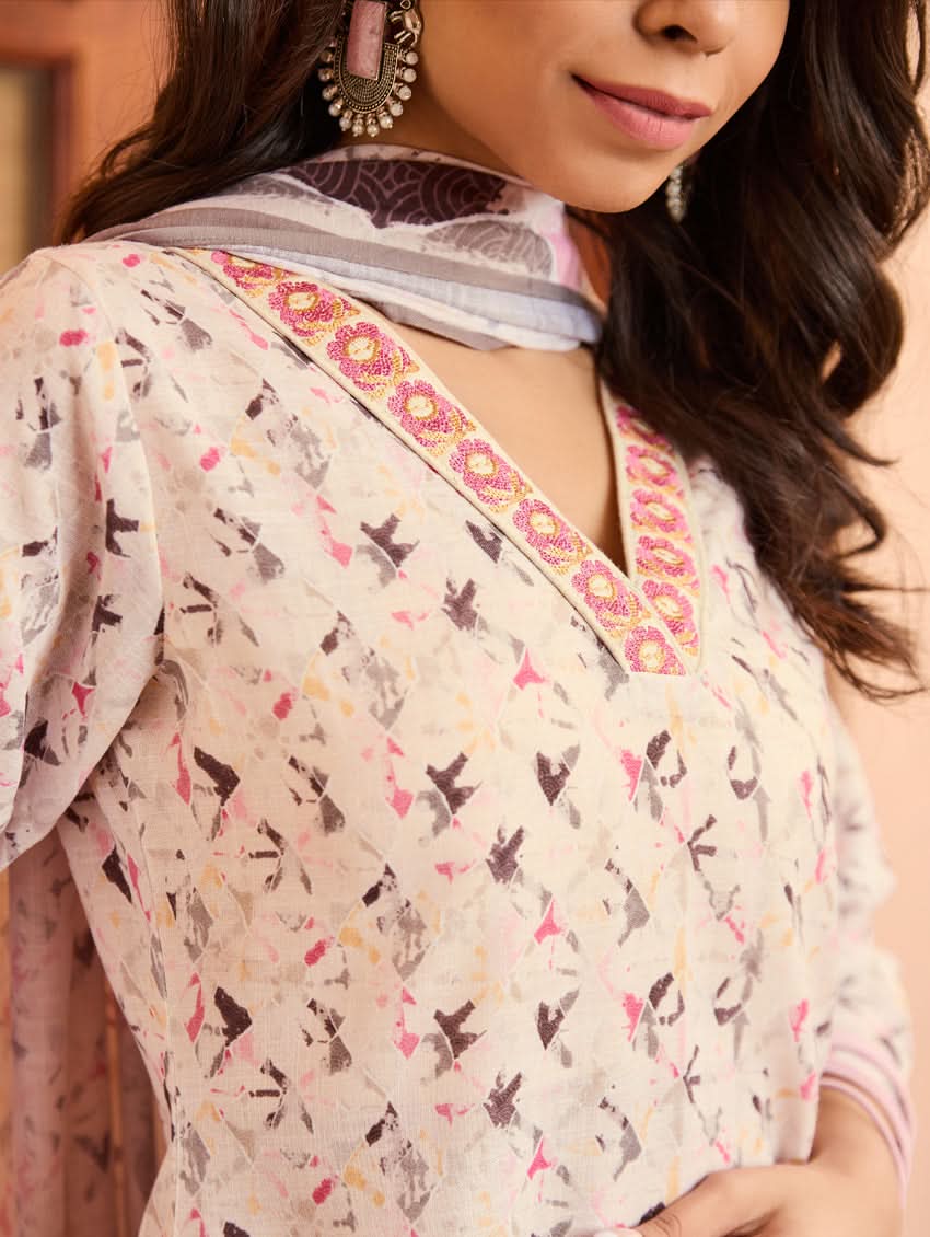 A woman standing outdoors wearing a digitally printed cotton suit set with a kurta, pants, and a dupatta in a floral pattern.