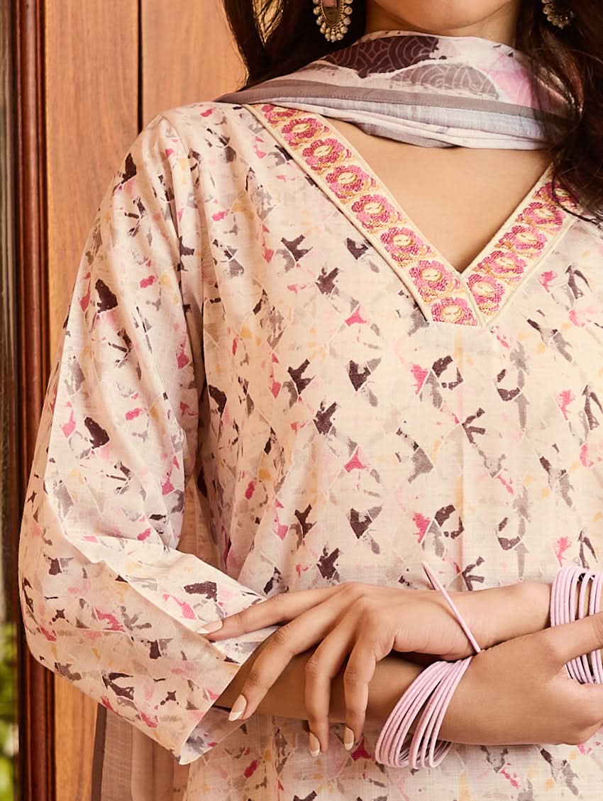 A woman standing outdoors wearing a digitally printed cotton suit set with a kurta, pants, and a dupatta in a floral pattern.