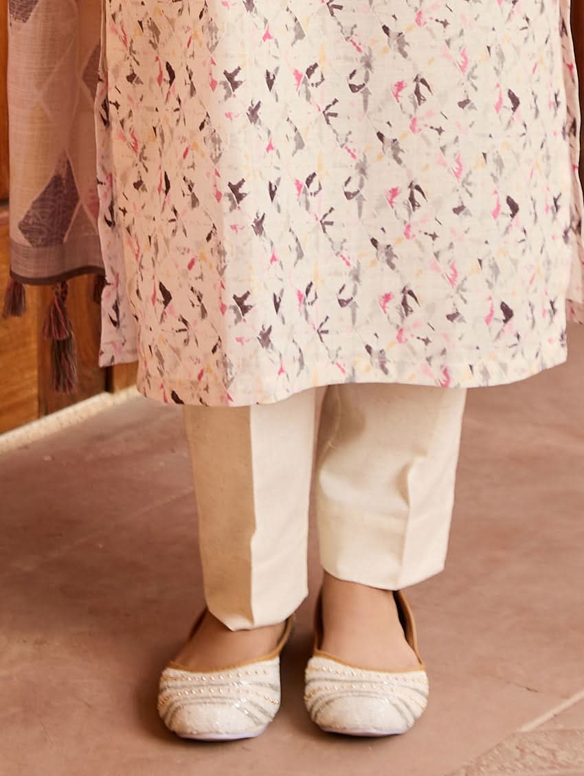 A woman standing outdoors wearing a digitally printed cotton suit set with a kurta, pants, and a dupatta in a floral pattern.