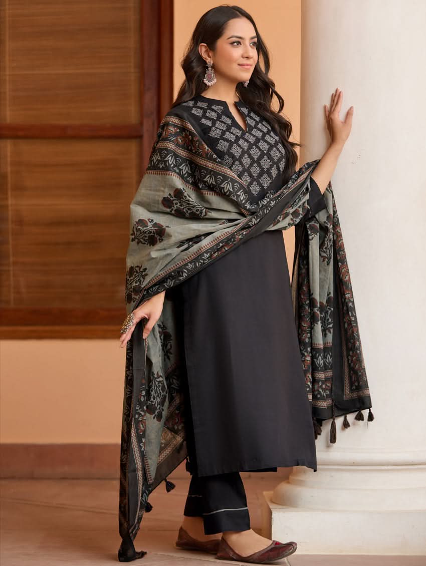 A woman wearing a black kurta with ban collar, three-fourth sleeves, and side slits, paired with black pants and a printed dupatta.
