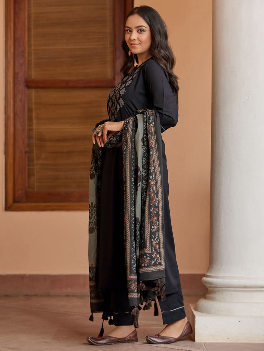 A woman wearing a black kurta with ban collar, three-fourth sleeves, and side slits, paired with black pants and a printed dupatta.