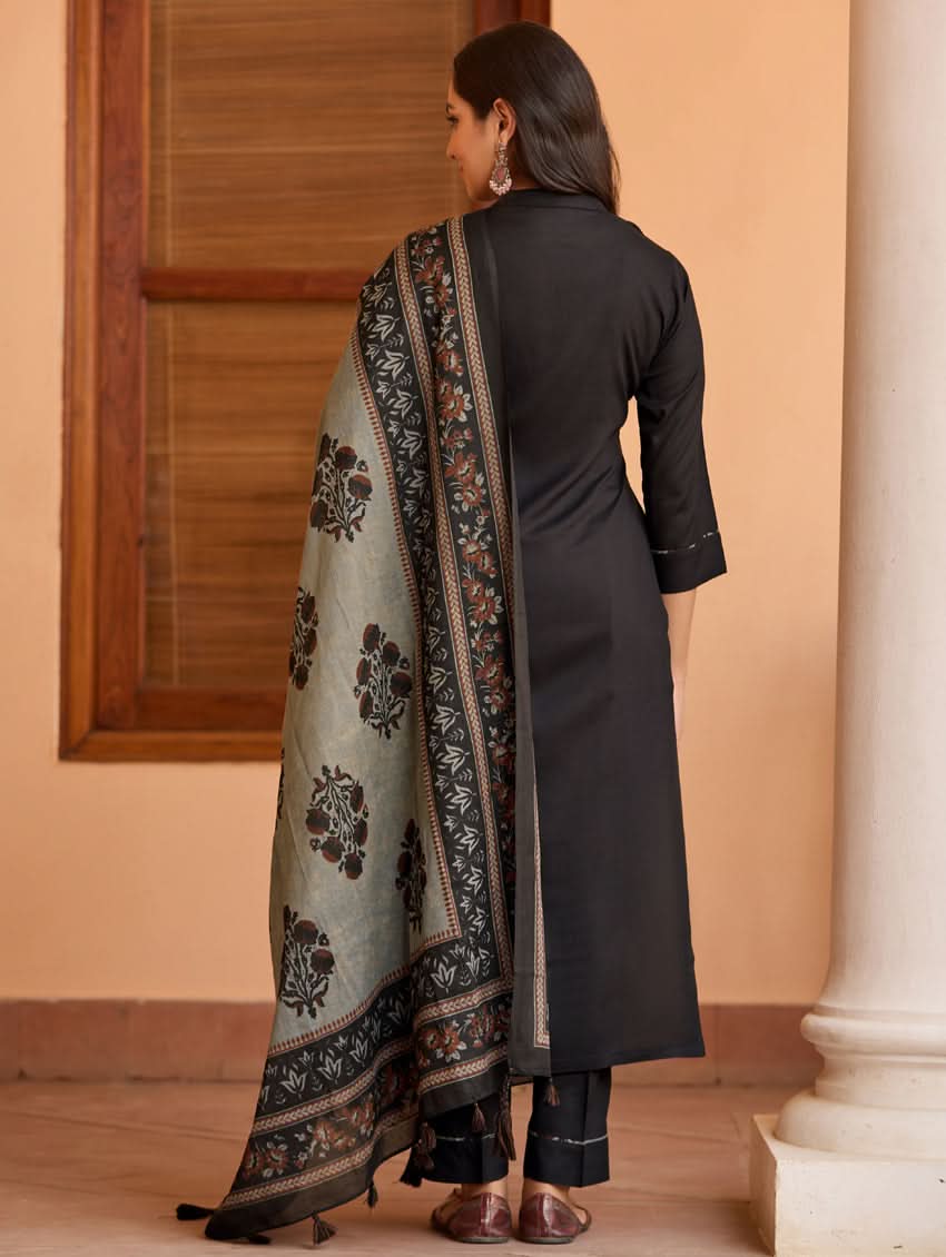 A woman wearing a black kurta with ban collar, three-fourth sleeves, and side slits, paired with black pants and a printed dupatta.
