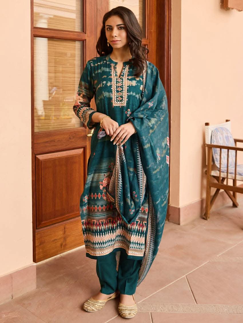 A woman wearing a blue viscose rayon suit set with hand embroidery on the kurta, consisting of a kurta with pants and a mul dupatta.