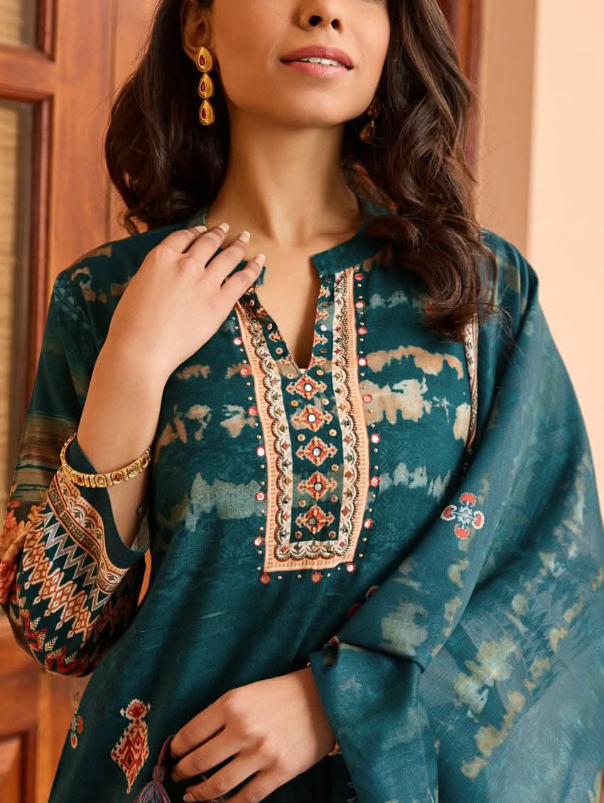 A woman wearing a blue viscose rayon suit set with hand embroidery on the kurta, consisting of a kurta with pants and a mul dupatta.