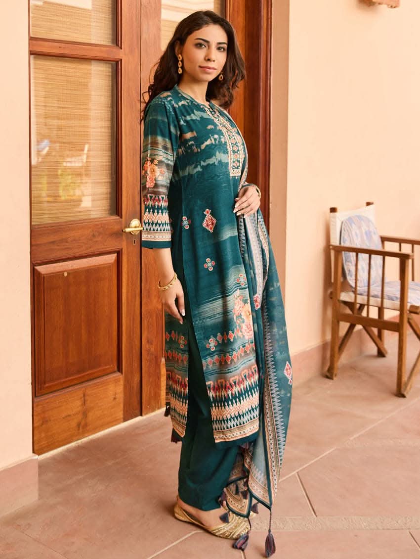 A woman wearing a blue viscose rayon suit set with hand embroidery on the kurta, consisting of a kurta with pants and a mul dupatta.