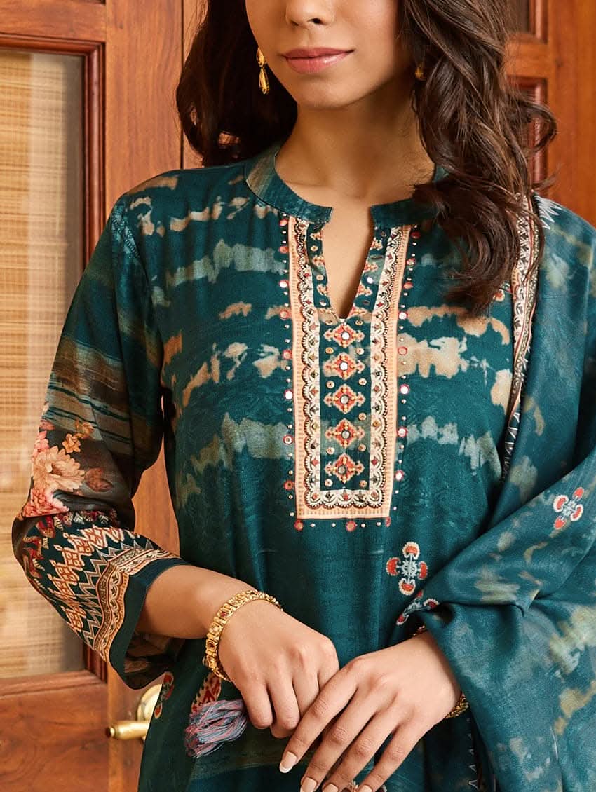 A woman wearing a blue viscose rayon suit set with hand embroidery on the kurta, consisting of a kurta with pants and a mul dupatta.