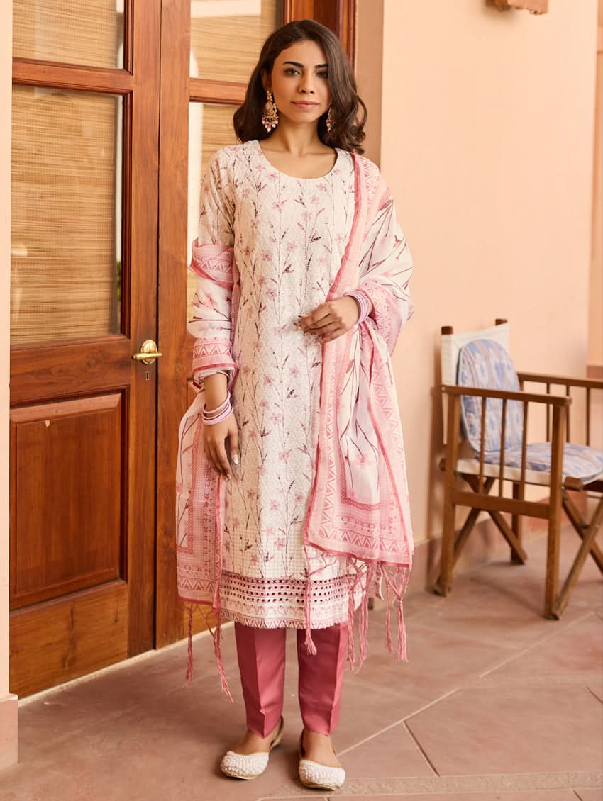 A woman wearing a Schiffli-embroidered rayon suit set with a kurta, straight pants, and a dupatta in pink and white colors.