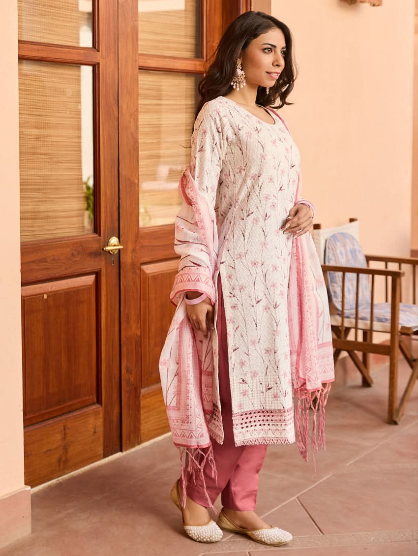 A woman wearing a Schiffli-embroidered rayon suit set with a kurta, straight pants, and a dupatta in pink and white colors.