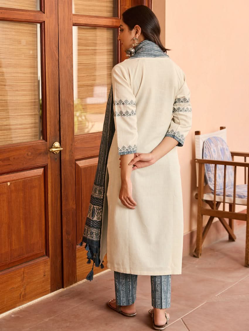 Cream tunic from back with blue embroidered sleeves, paired with striped pants