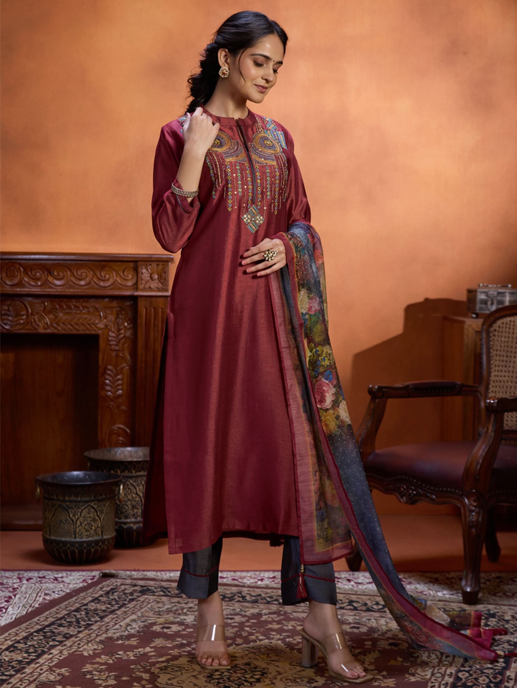 A woman wearing a maroon viscose silk suit set with computerised thread embroidery and a digitally printed dupatta.
