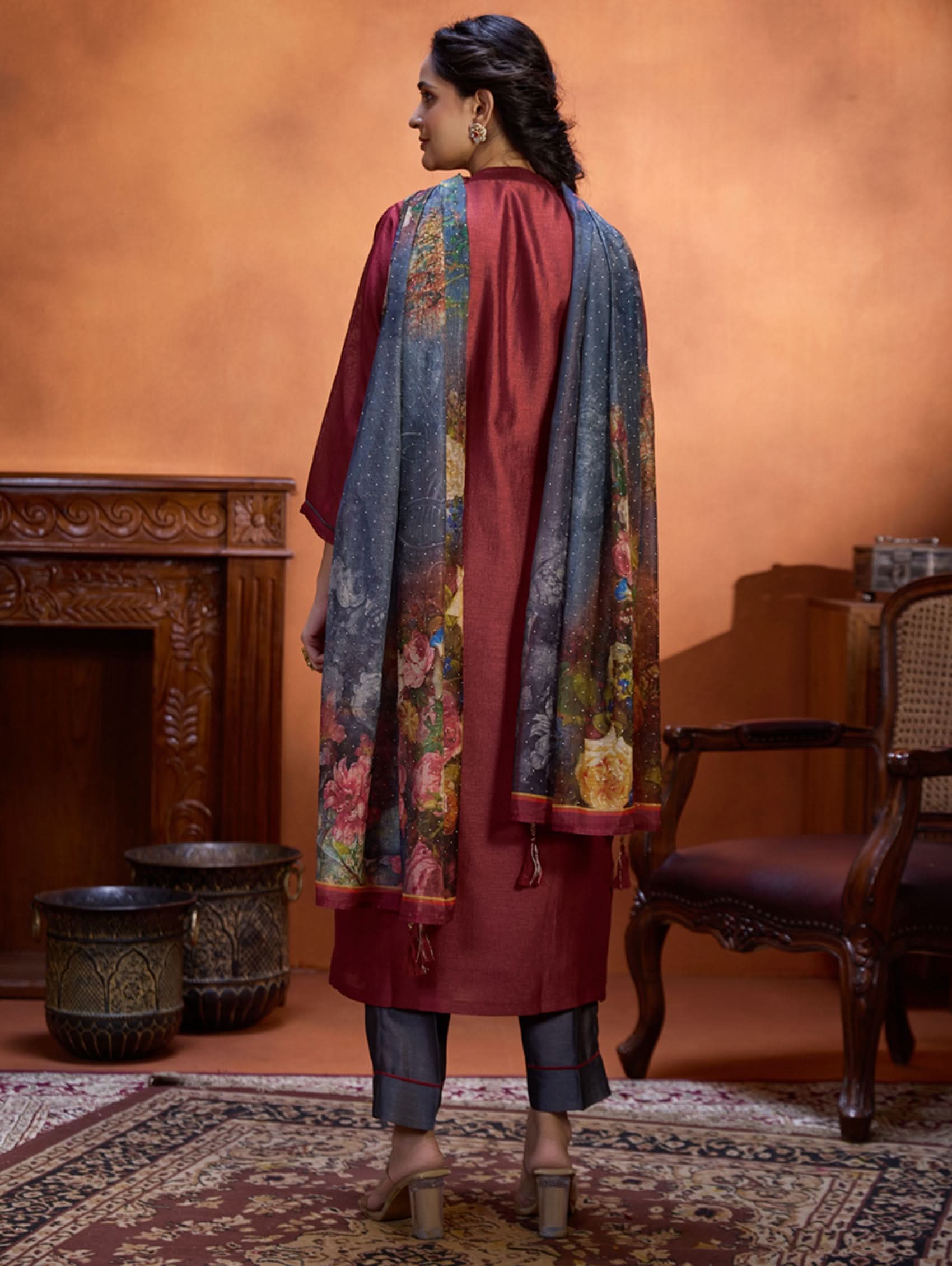 A woman wearing a maroon viscose silk suit set with computerised thread embroidery and a digitally printed dupatta.