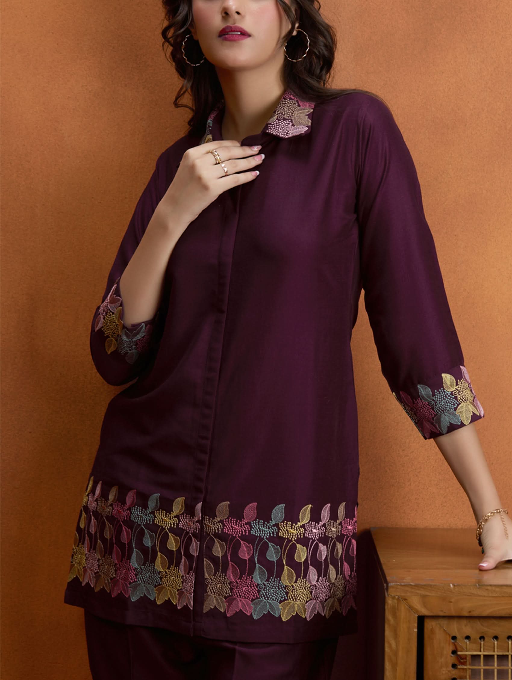 Dark maroon embroidered tunic top with button front, floral cuff and hem trim