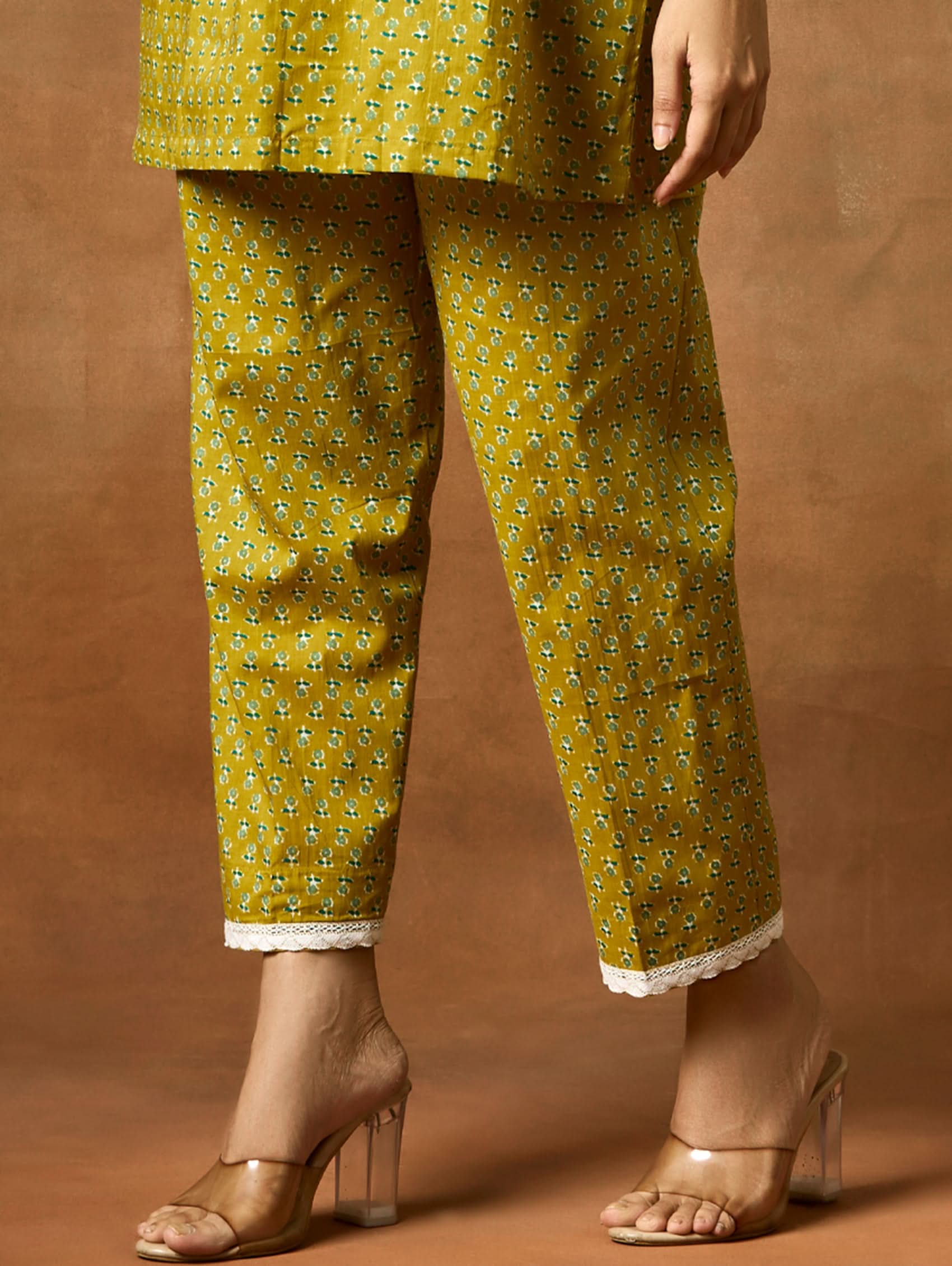 A model wearing a green pure cotton kurta with short sleeves and V-neckline, paired with matching pants, showcasing computerised thread embroidery.