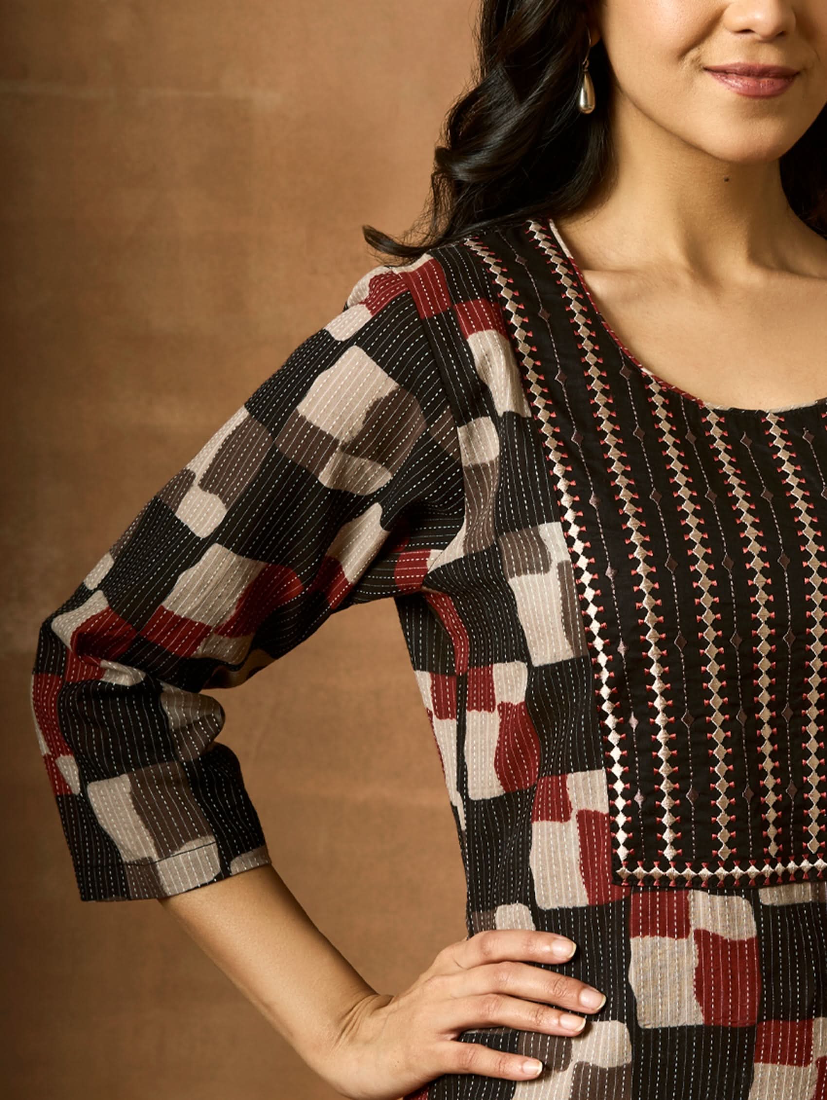 Woman wearing a patterned dress with a brown background
