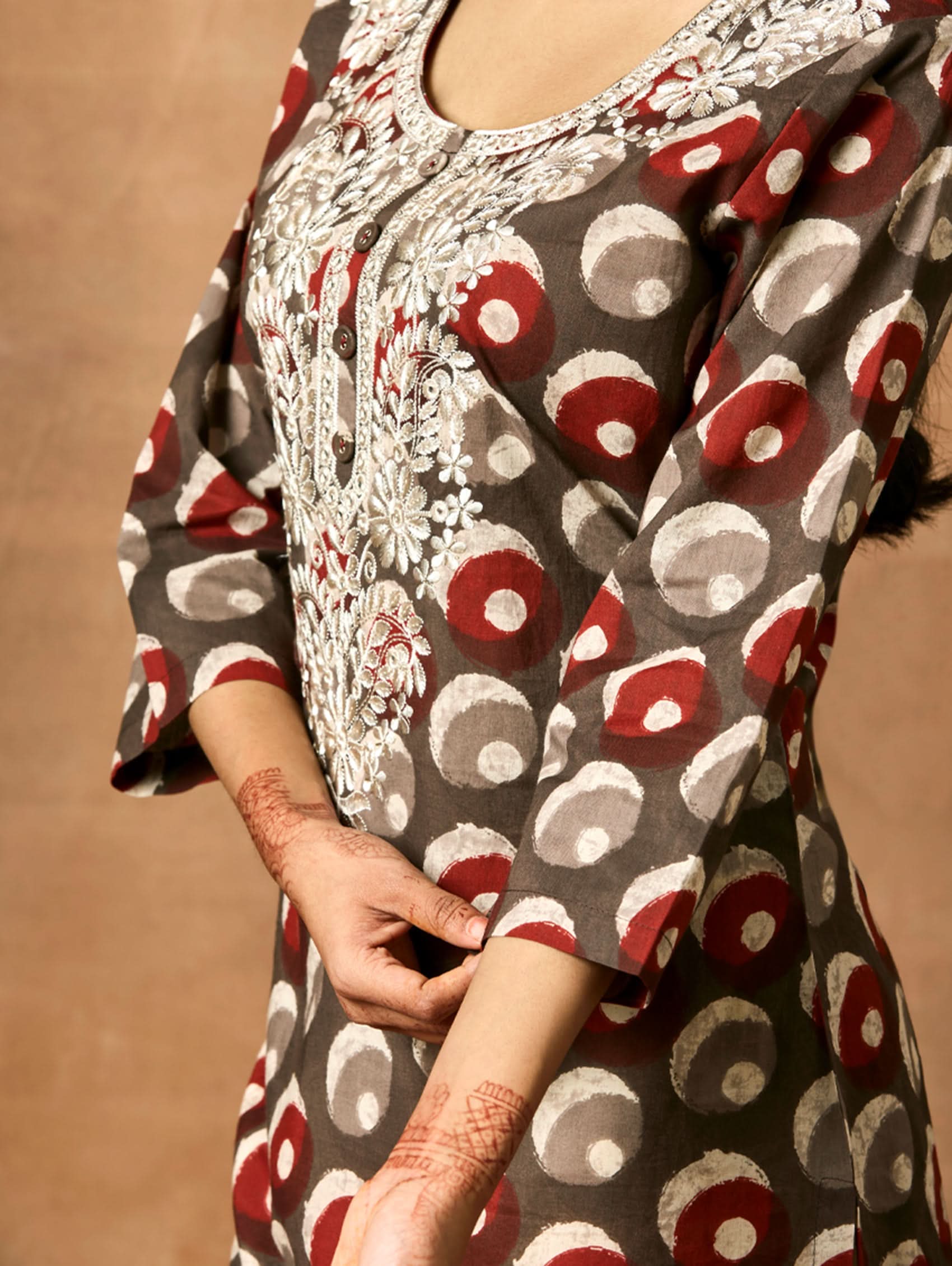 Close-up of a person wearing a patterned dress with intricate lace detailing.