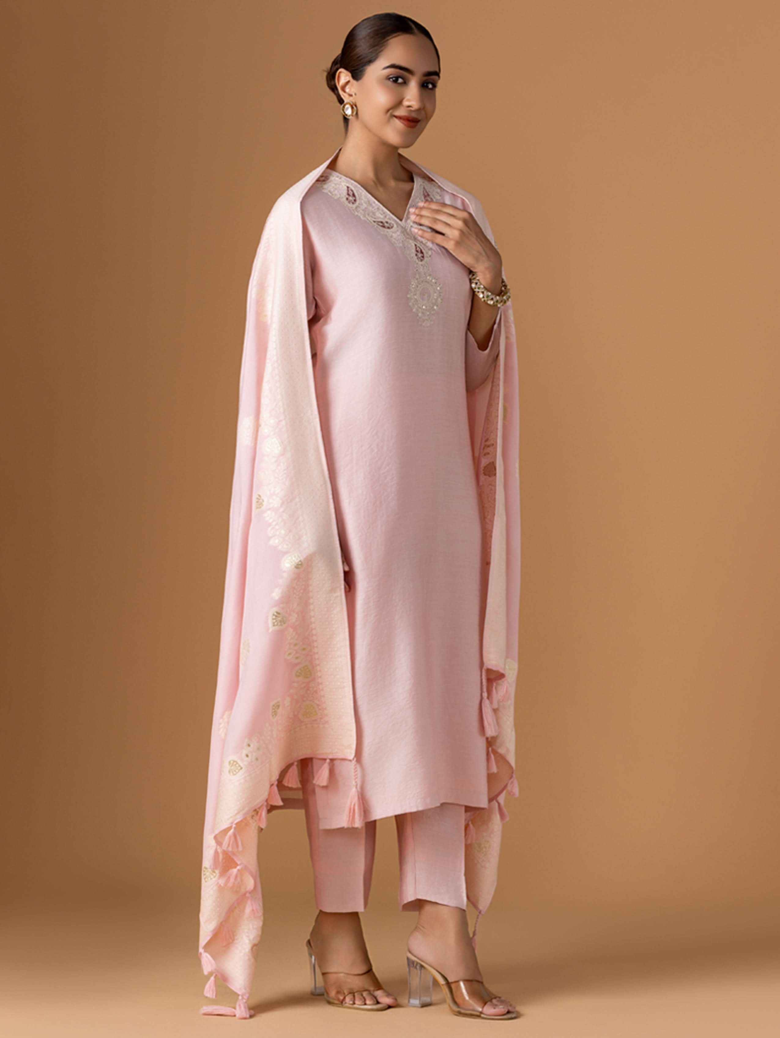 Woman wearing a pink traditional outfit with a beige background
