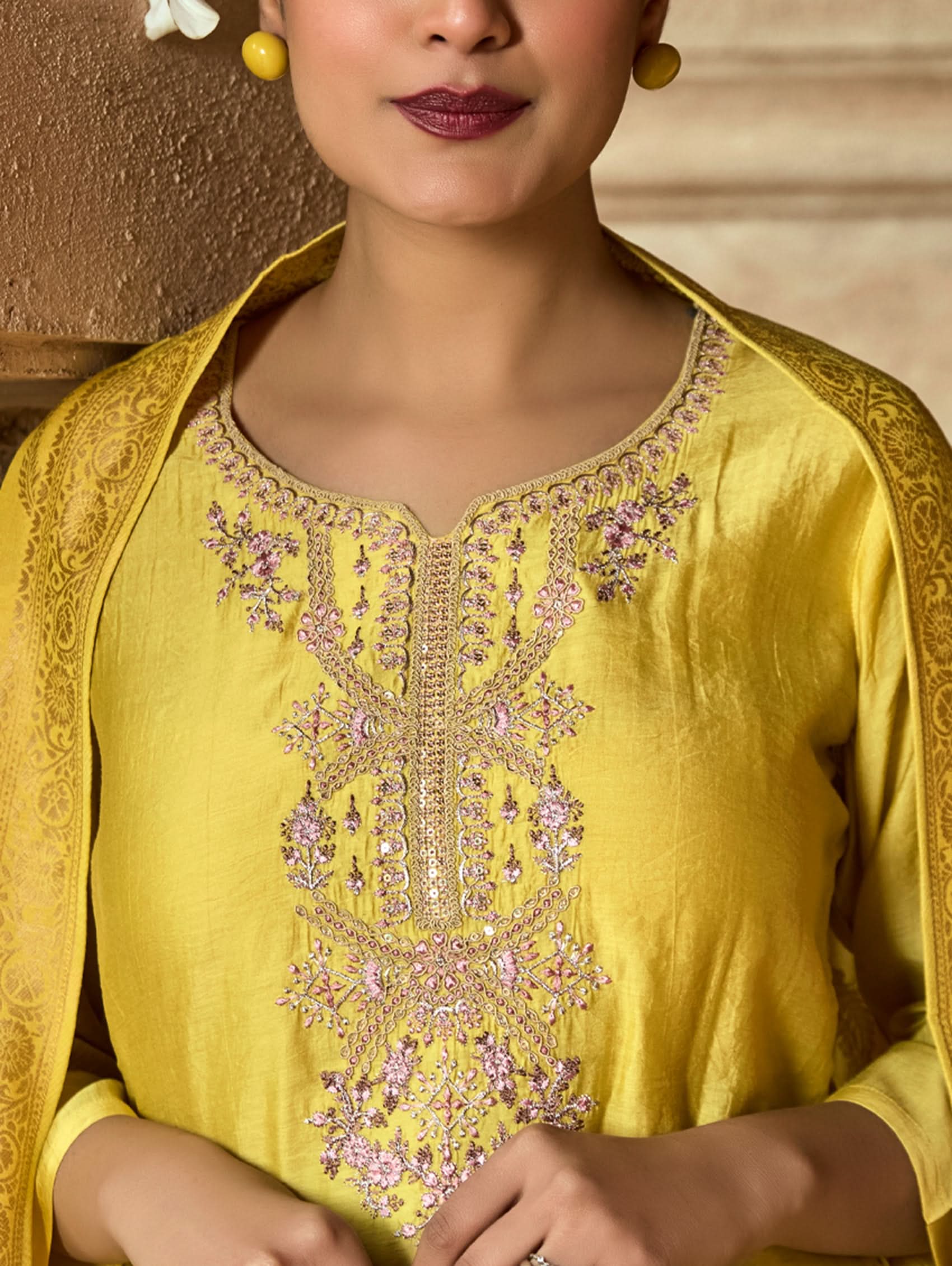 Close-up of a yellow garment with intricate embroidery.