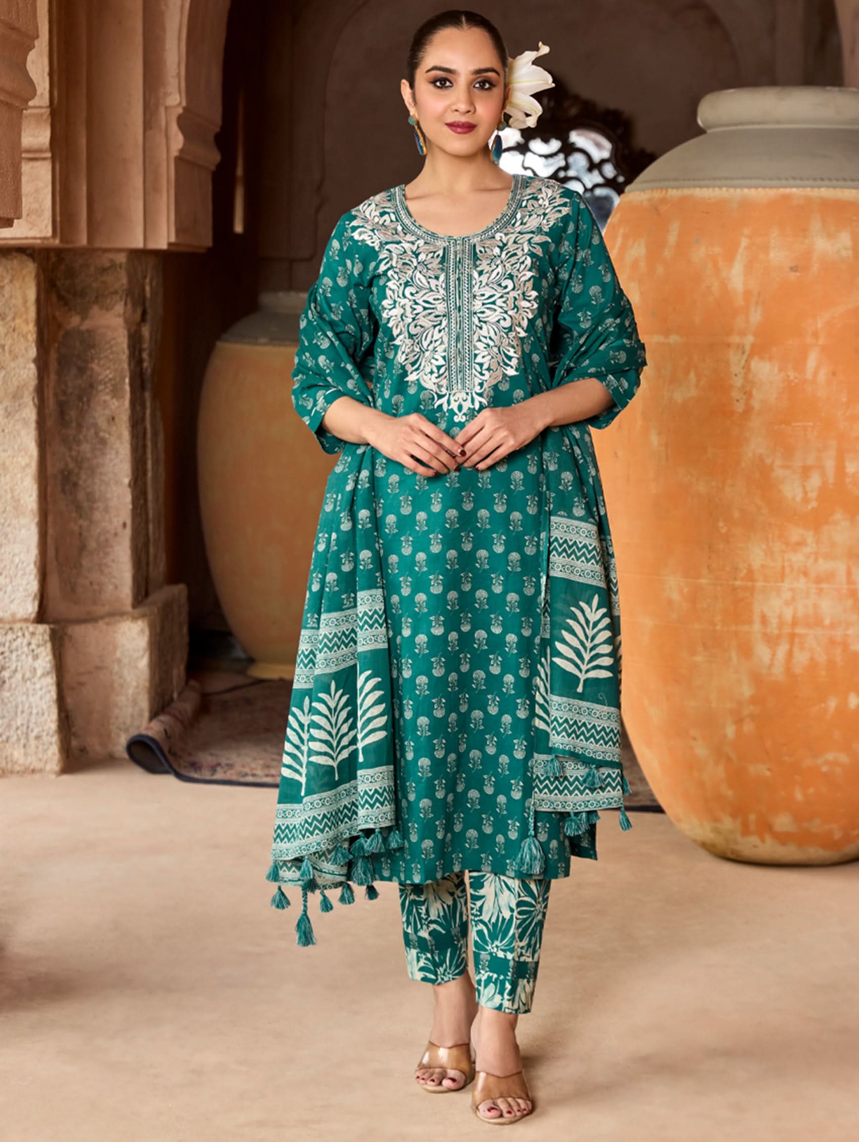 A woman wearing a green and white embroidered pure cotton suit set with three-quarter sleeves and side slits, including straight pants and a printed cotton dupatta.