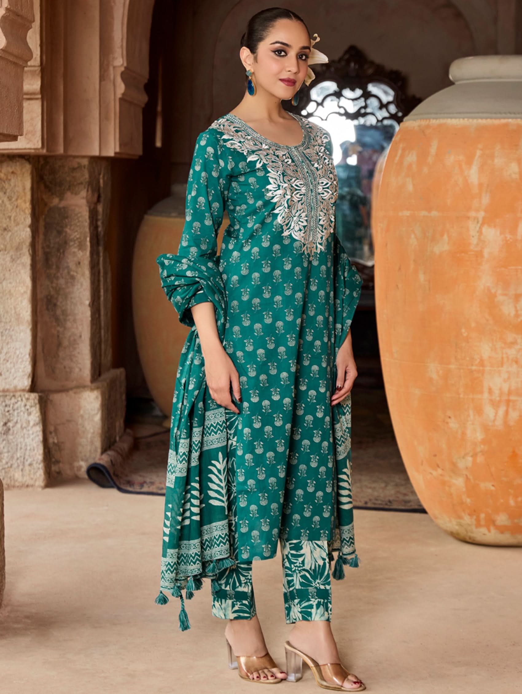 A woman wearing a green and white embroidered pure cotton suit set with three-quarter sleeves and side slits, including straight pants and a printed cotton dupatta.