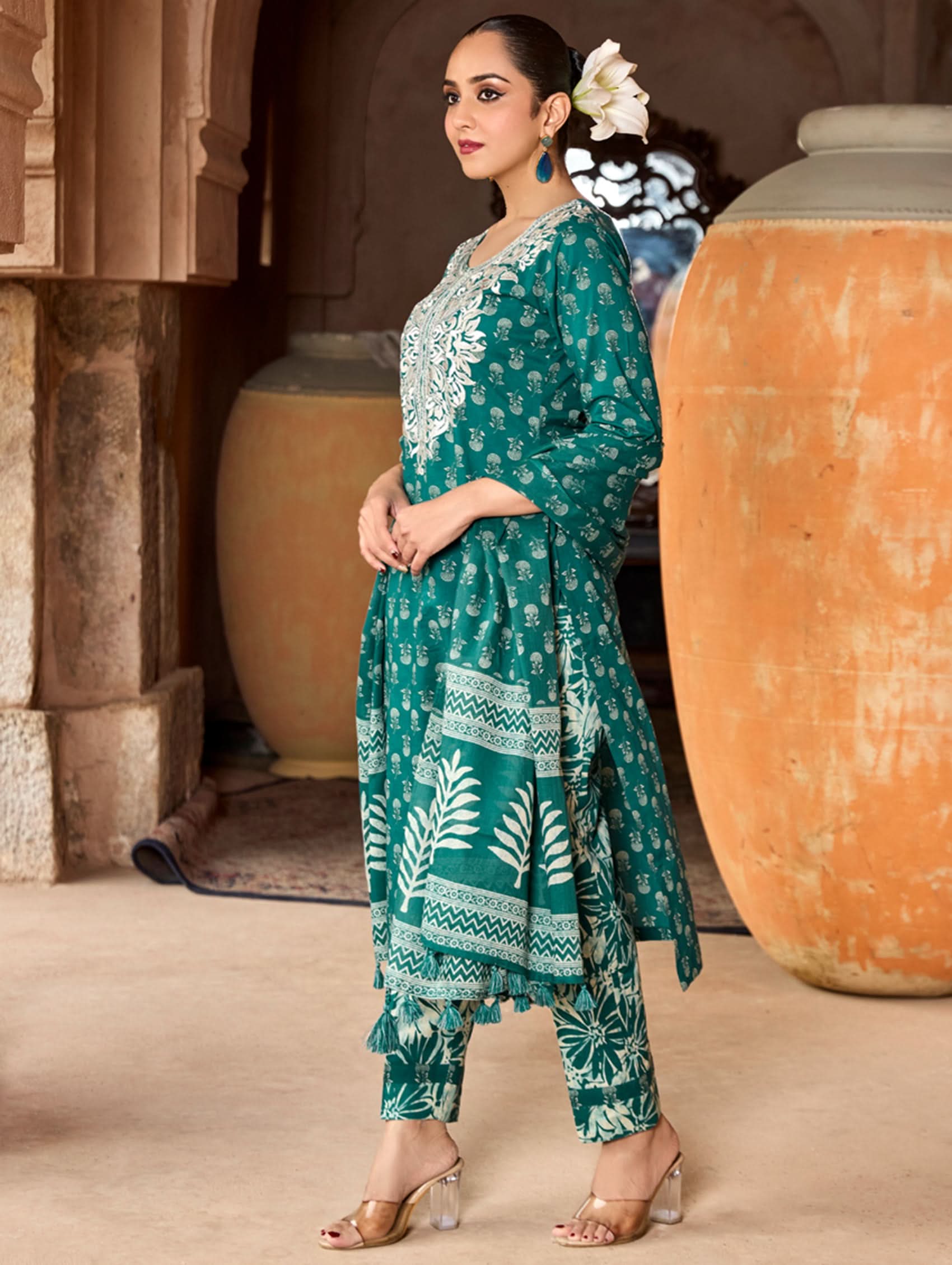A woman wearing a green and white embroidered pure cotton suit set with three-quarter sleeves and side slits, including straight pants and a printed cotton dupatta.