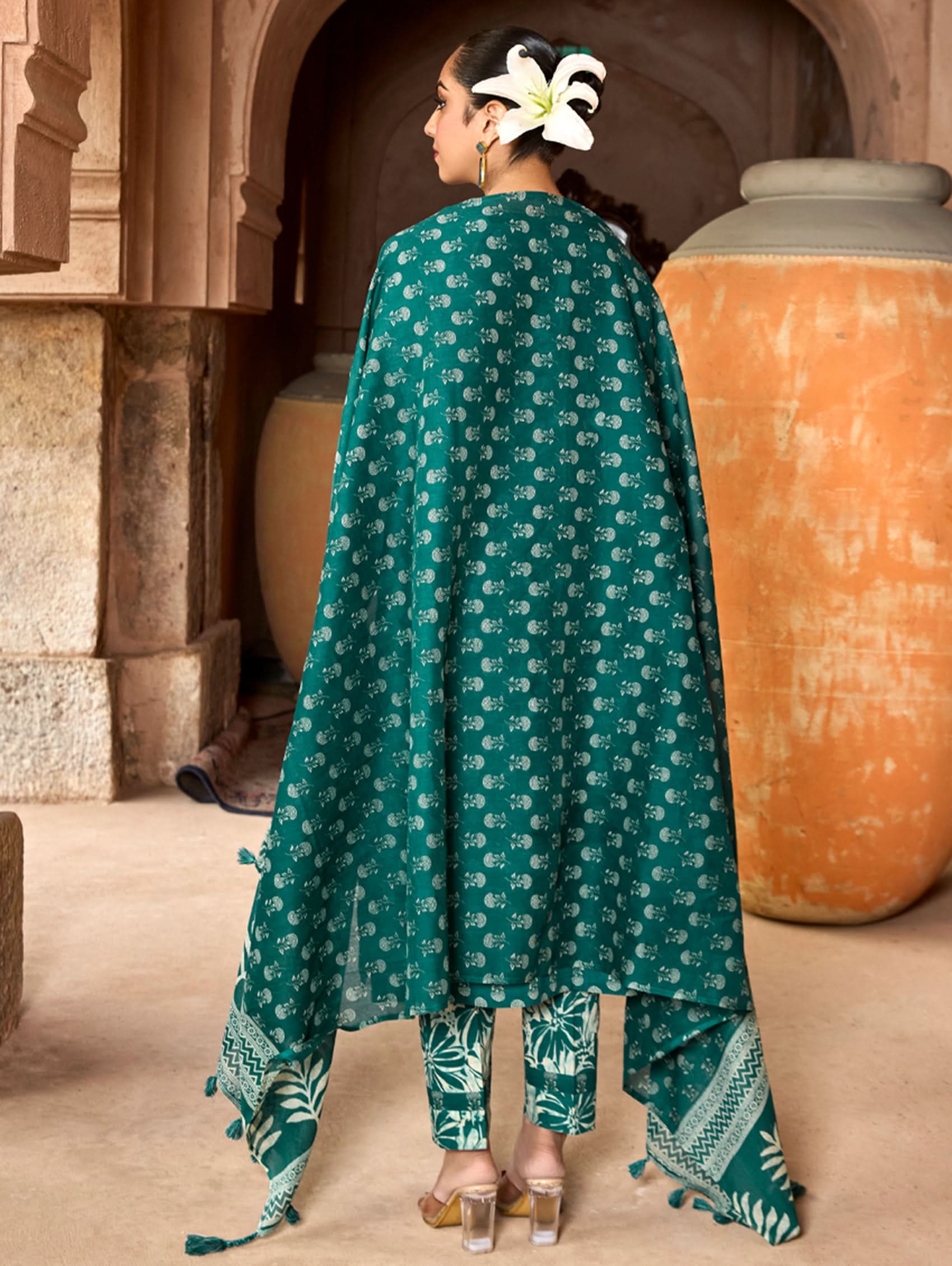 A woman wearing a green and white embroidered pure cotton suit set with three-quarter sleeves and side slits, including straight pants and a printed cotton dupatta.