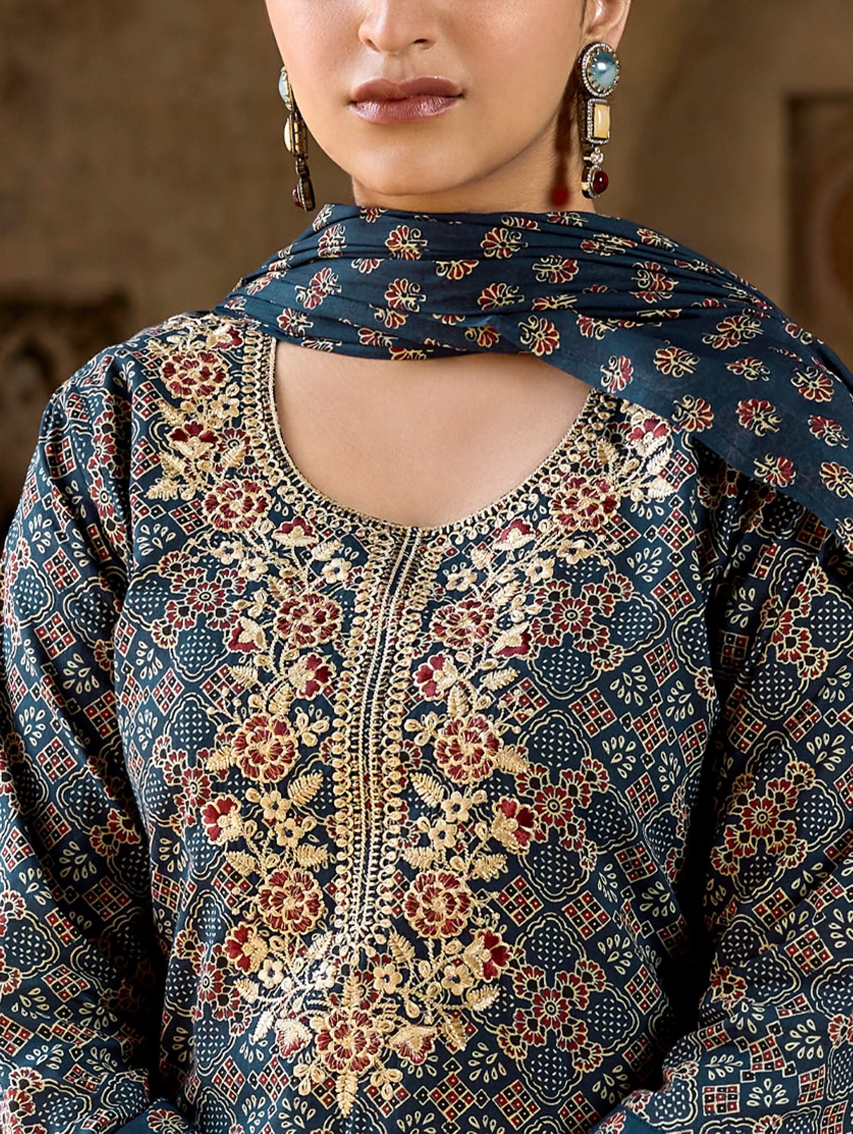 A woman wearing a green and white embroidered pure cotton suit set with three-quarter sleeves and side slits, including straight pants and a printed cotton dupatta.