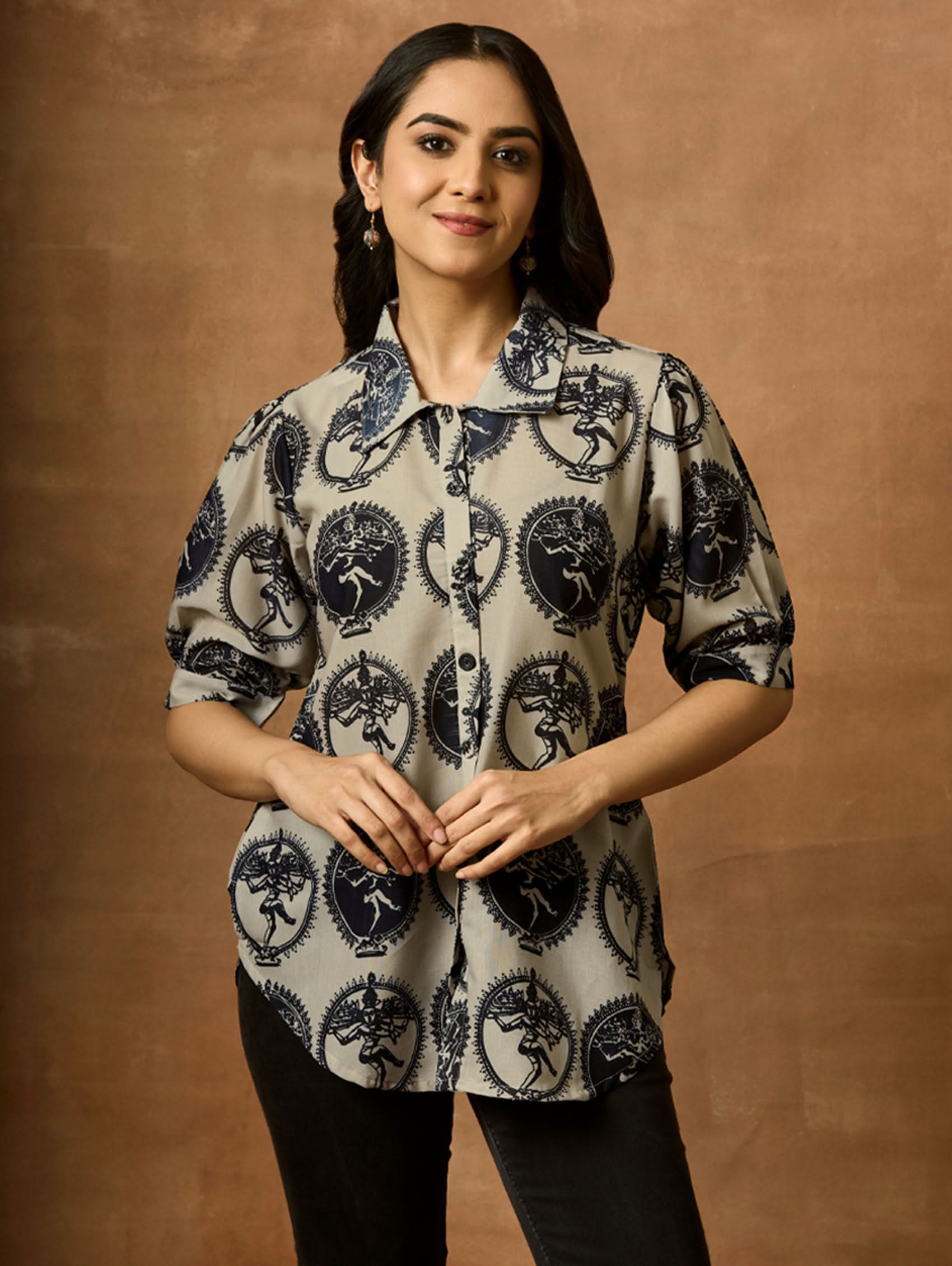 A woman wearing a beige and navy printed summer cool viscose tunic with a revere collar and half-length sleeves.