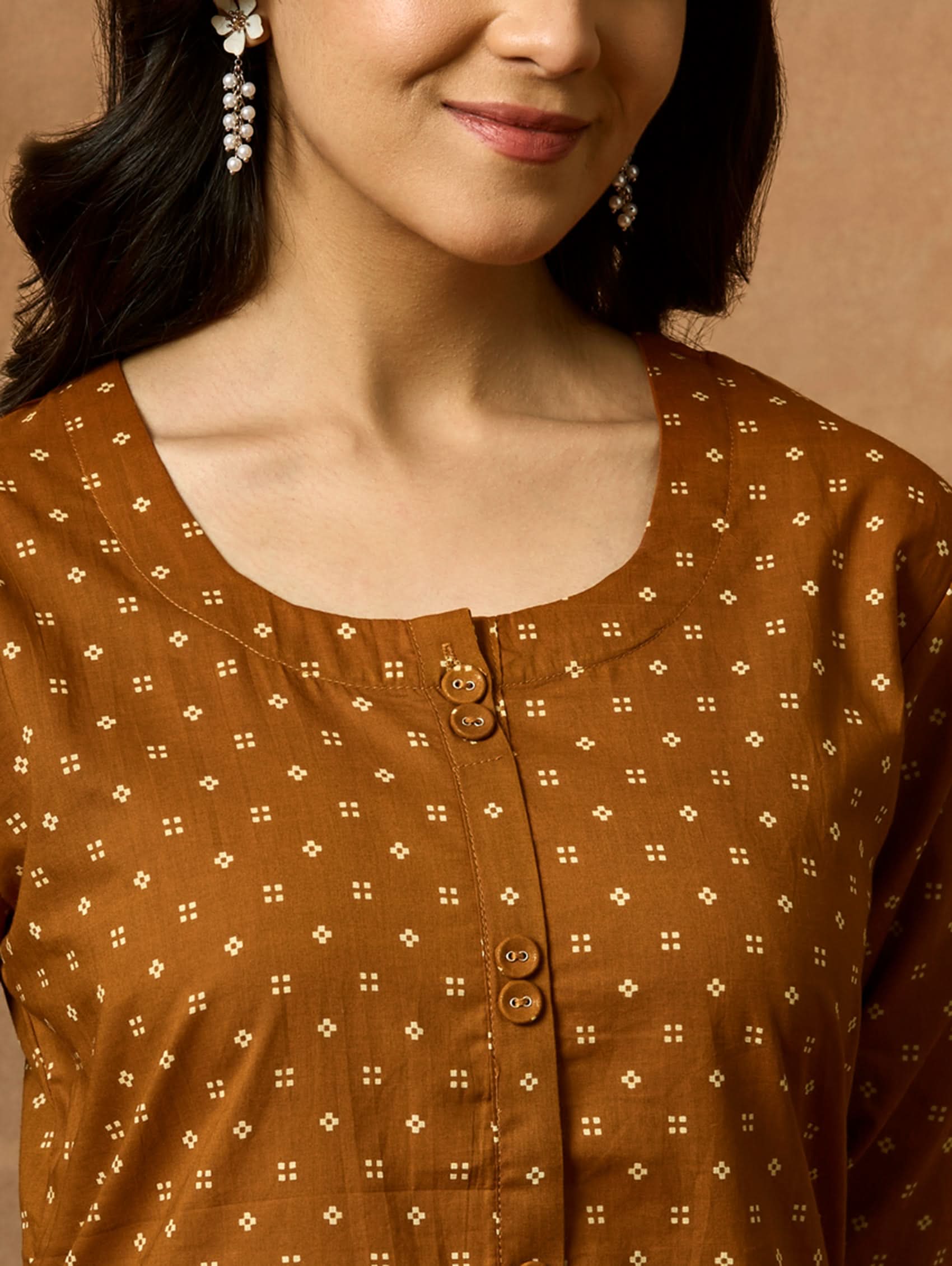 Close-up of a brown patterned shirt worn by a person.